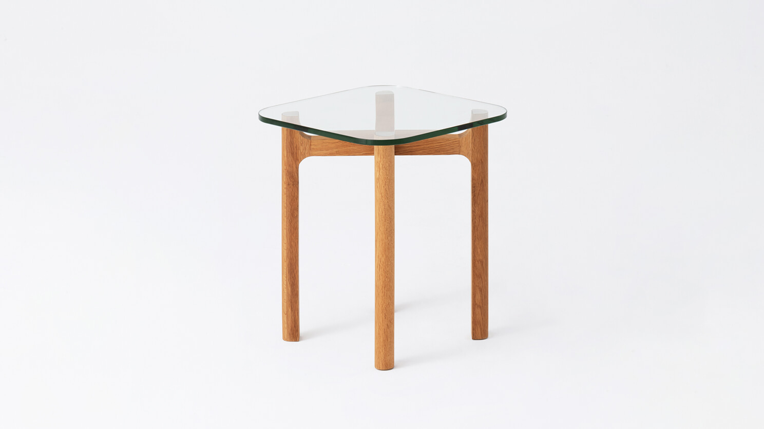 Side view of the Place square accent table with clear glass top and oak legs