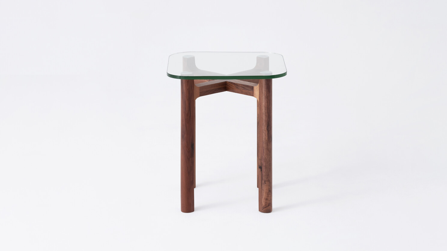 Front view of the Place square accent table with clear glass top and walnut legs