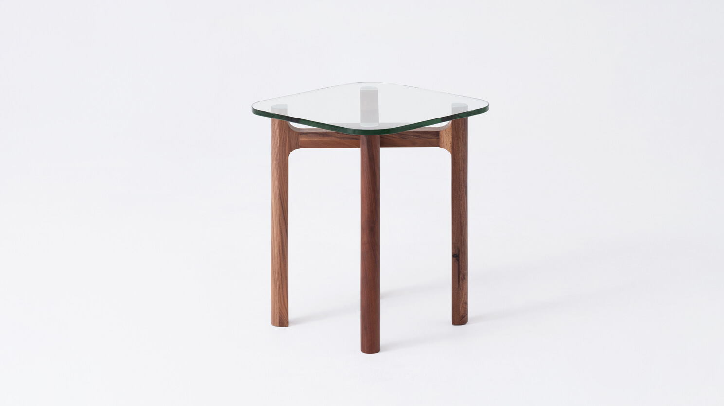 Side view of the Place square accent table with clear glass top and walnut legs