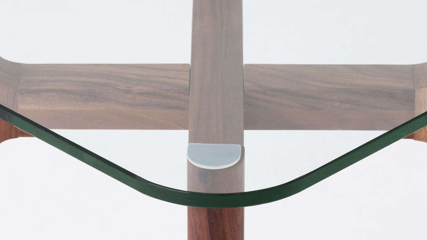 Detail view of the Place square accent table with clear glass top and walnut legs