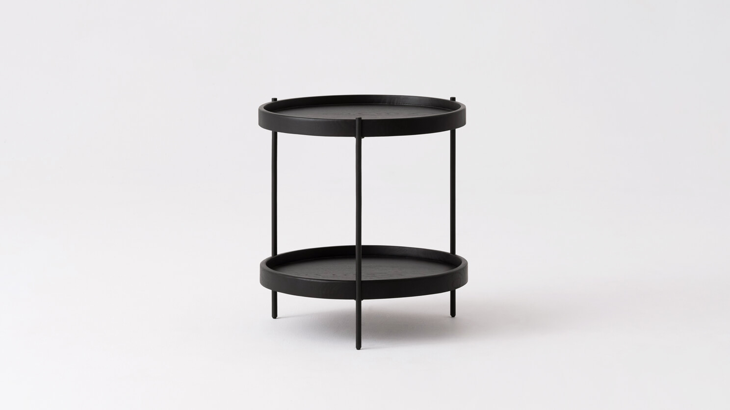 Side view of the Sage modern round end table in black oak