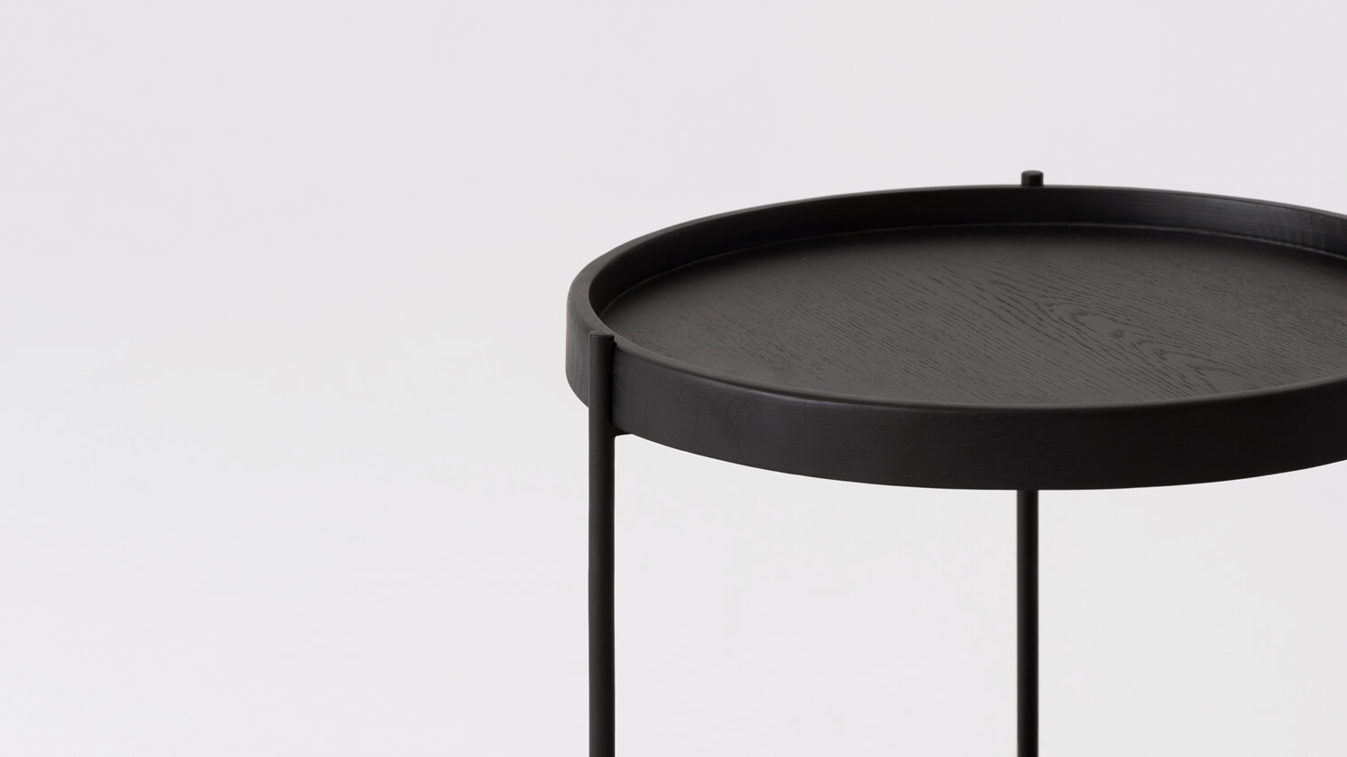 Detail view of the Sage modern round end table in black oak