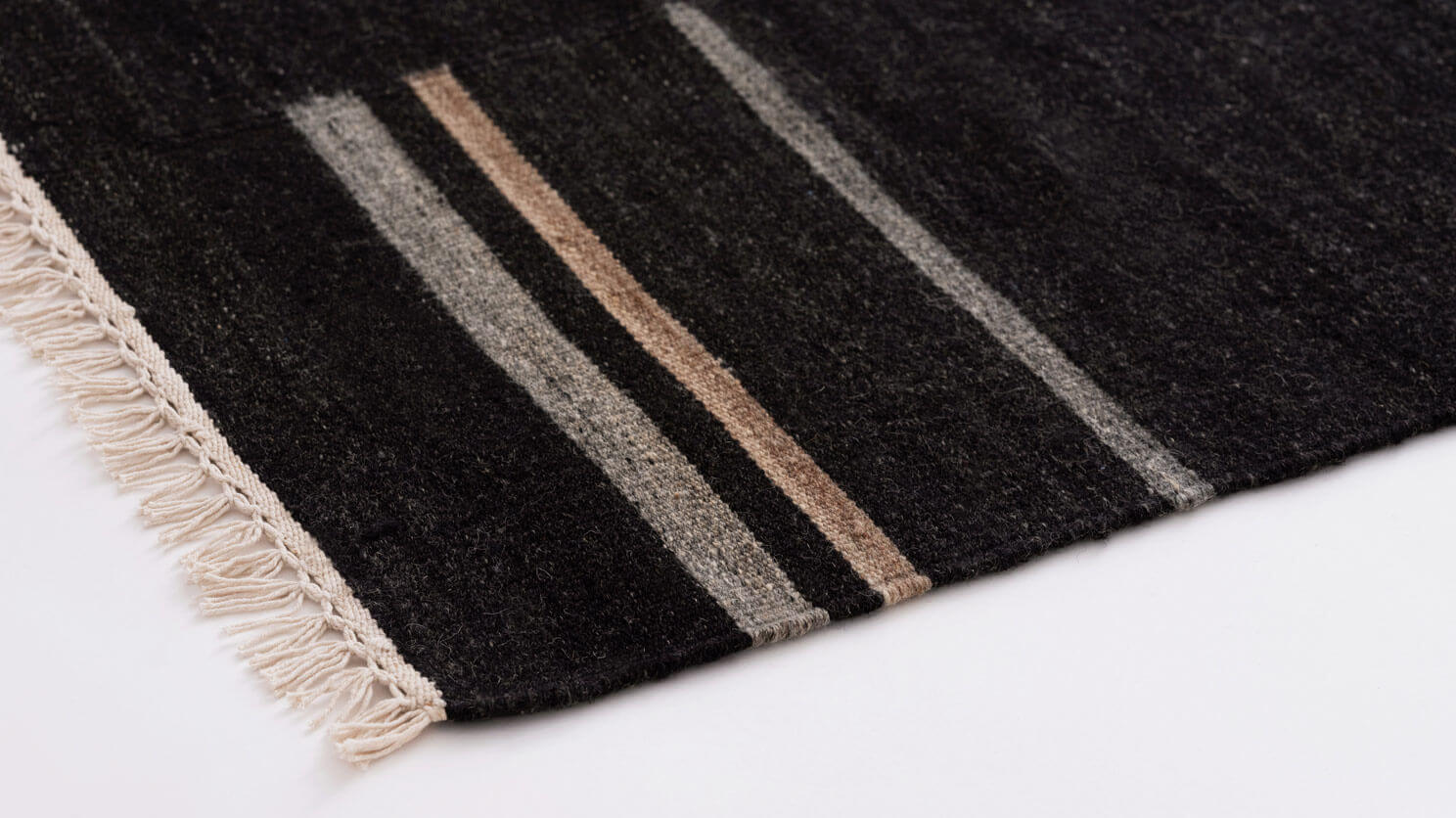 Detail view of black area rug with grey and brown stripes