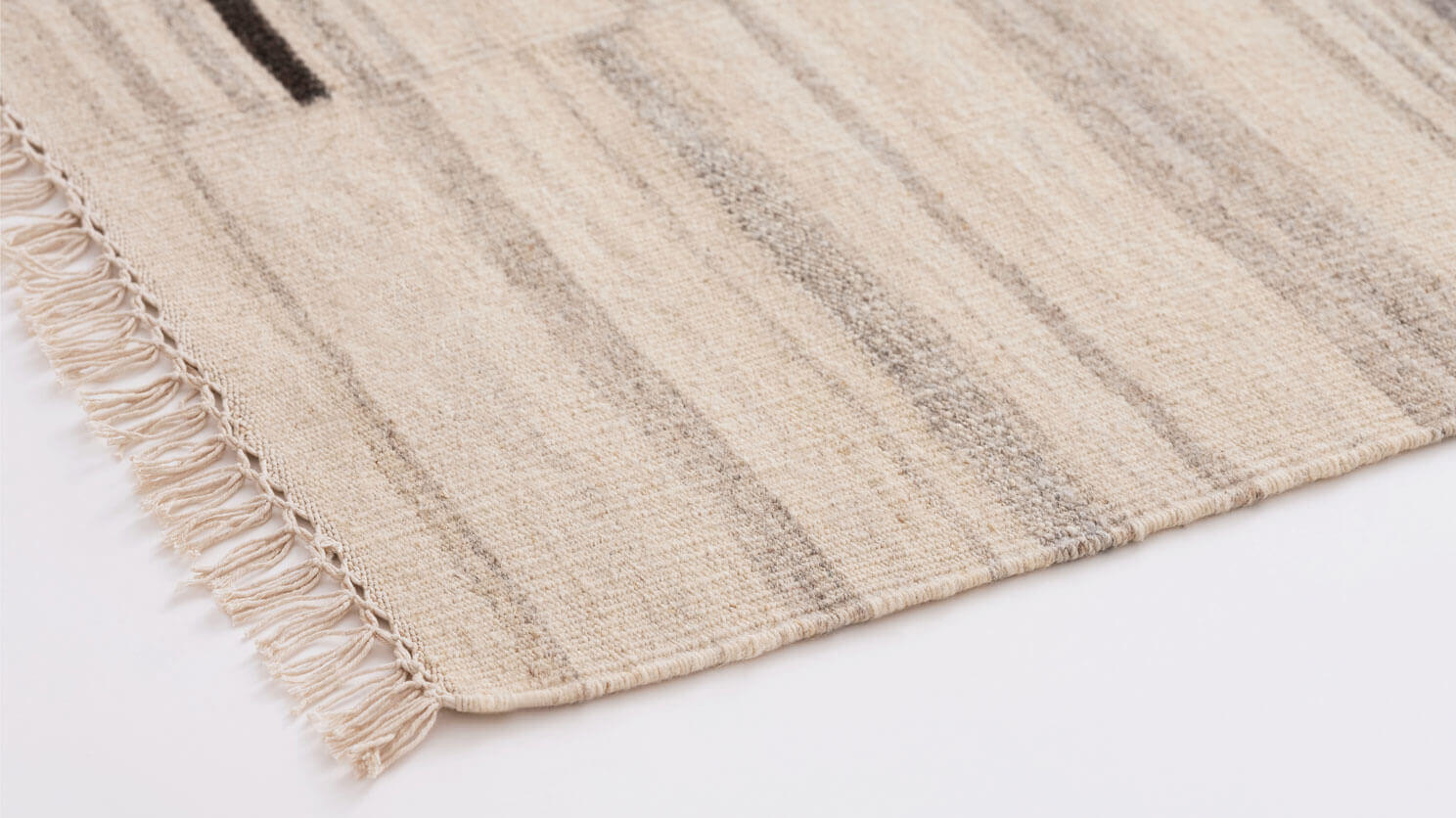 Ivory area rug with grey and black stripes detail corner view