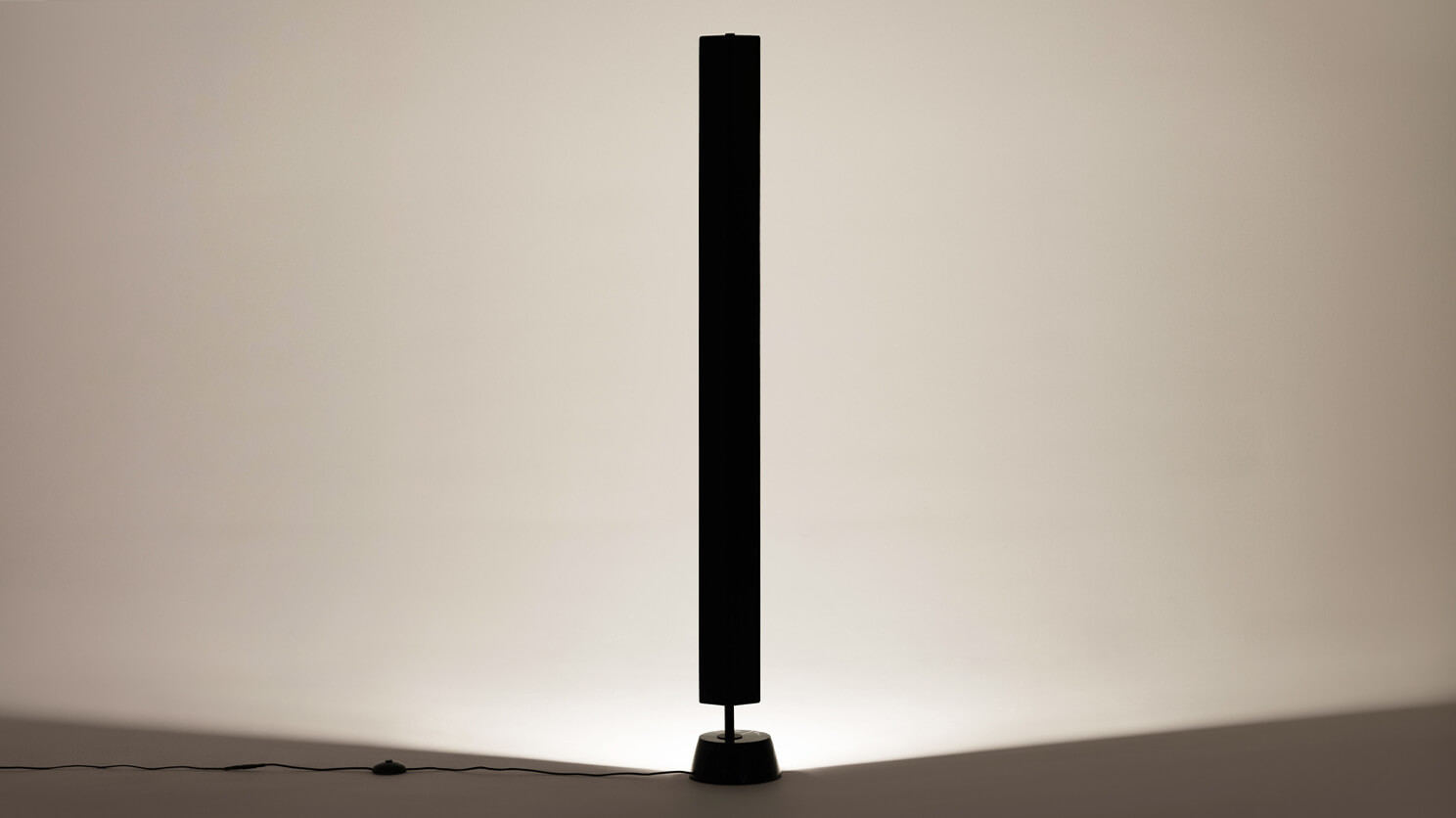 Front view of the Oxford Dunce mid century modern floor lamp with light on