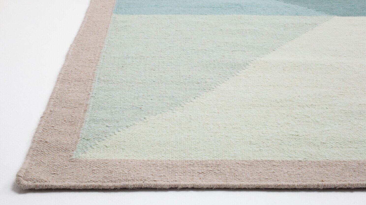 Detail view of the modern handwoven wool rug in teal