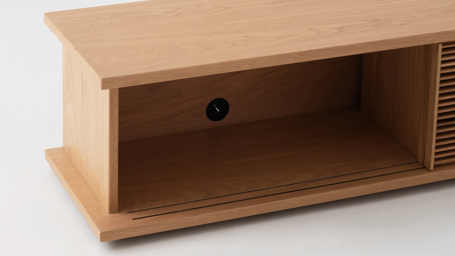 Detail view of the Plank mid century media console in oak with slatted door open