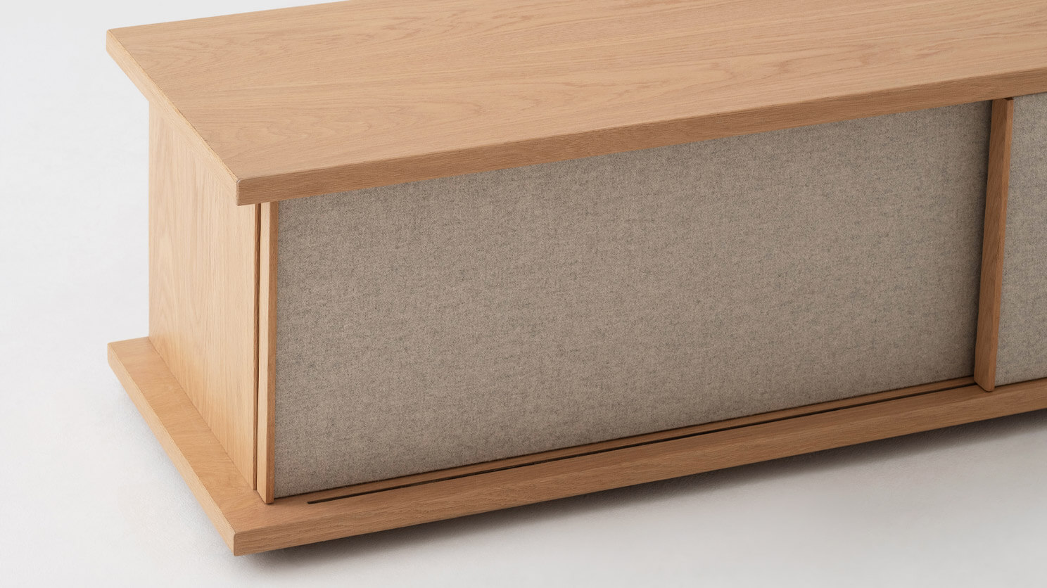 Angled view of the Plank mid century media console in oak with fabric panels