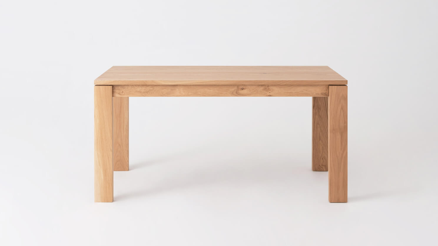 Front view of the small Bon solid wood dining table in oak