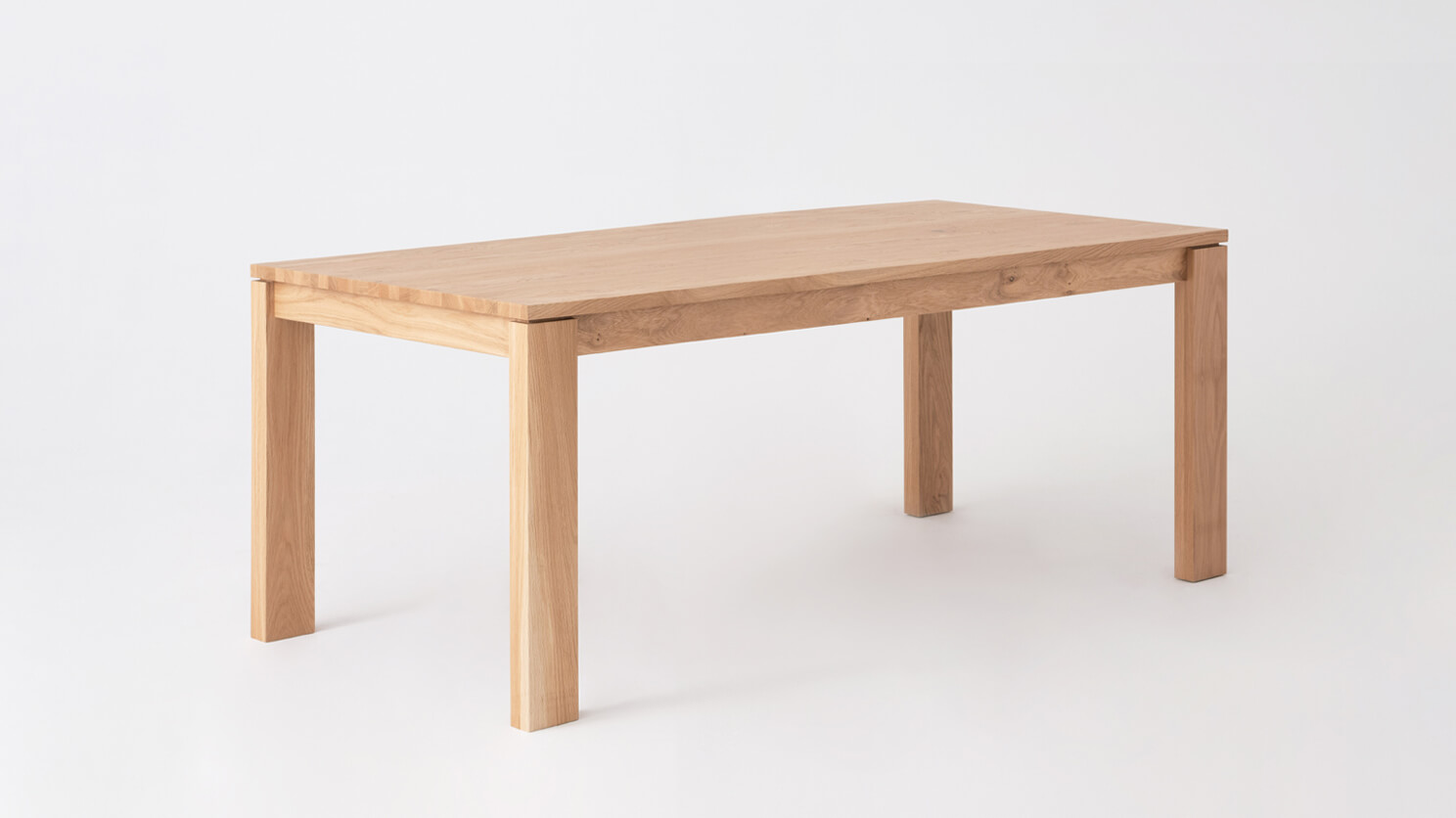 Angled view of the small Bon expanded solid wood dining table in oak