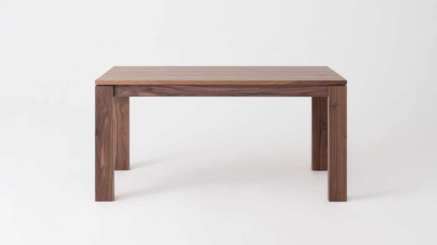 Front view of the small Bon solid wood dining table in walnut