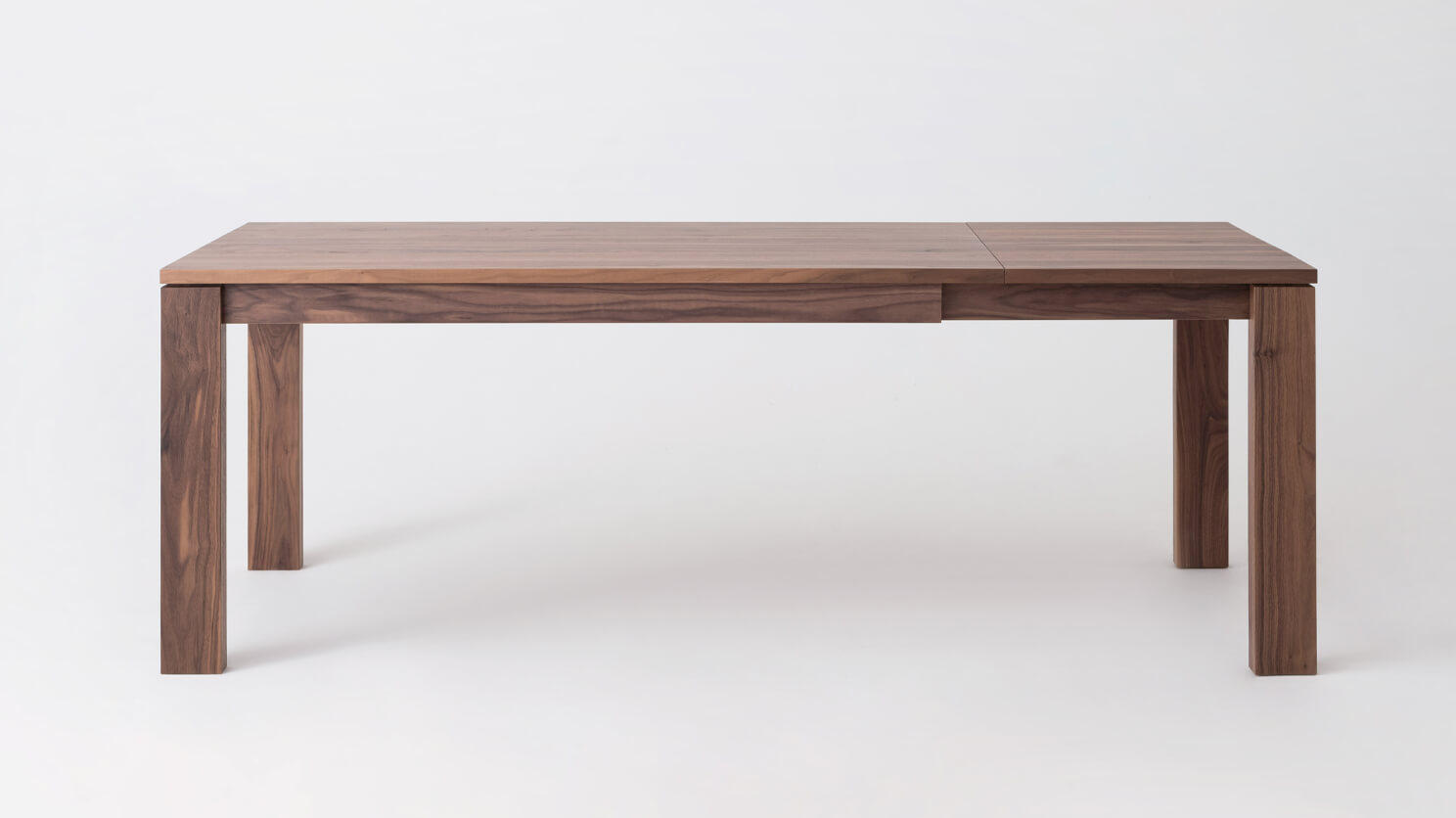 Front view of the large Bon solid wood dining table in walnut