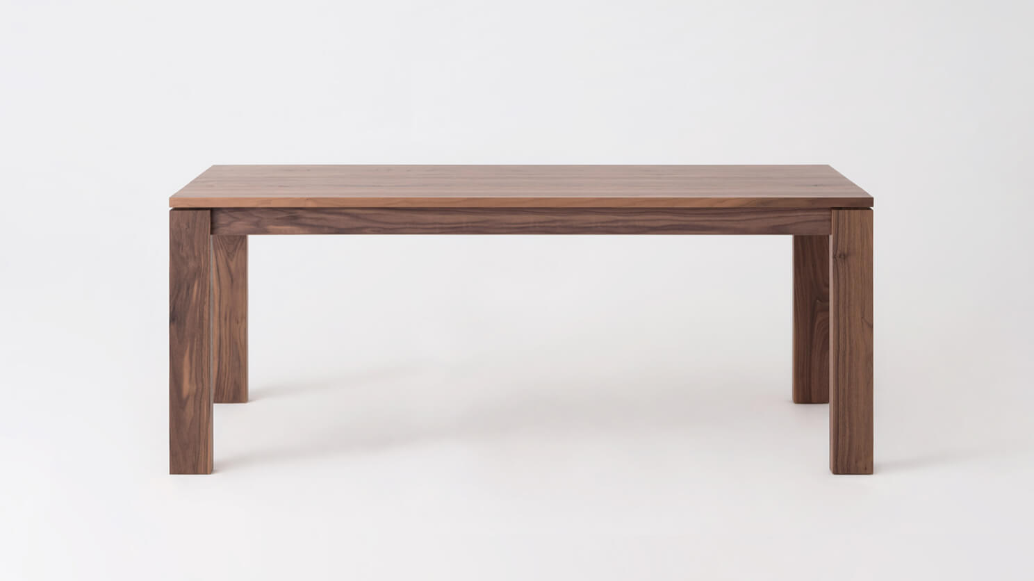 Front view of the small Bon expanded solid wood dining table in walnut