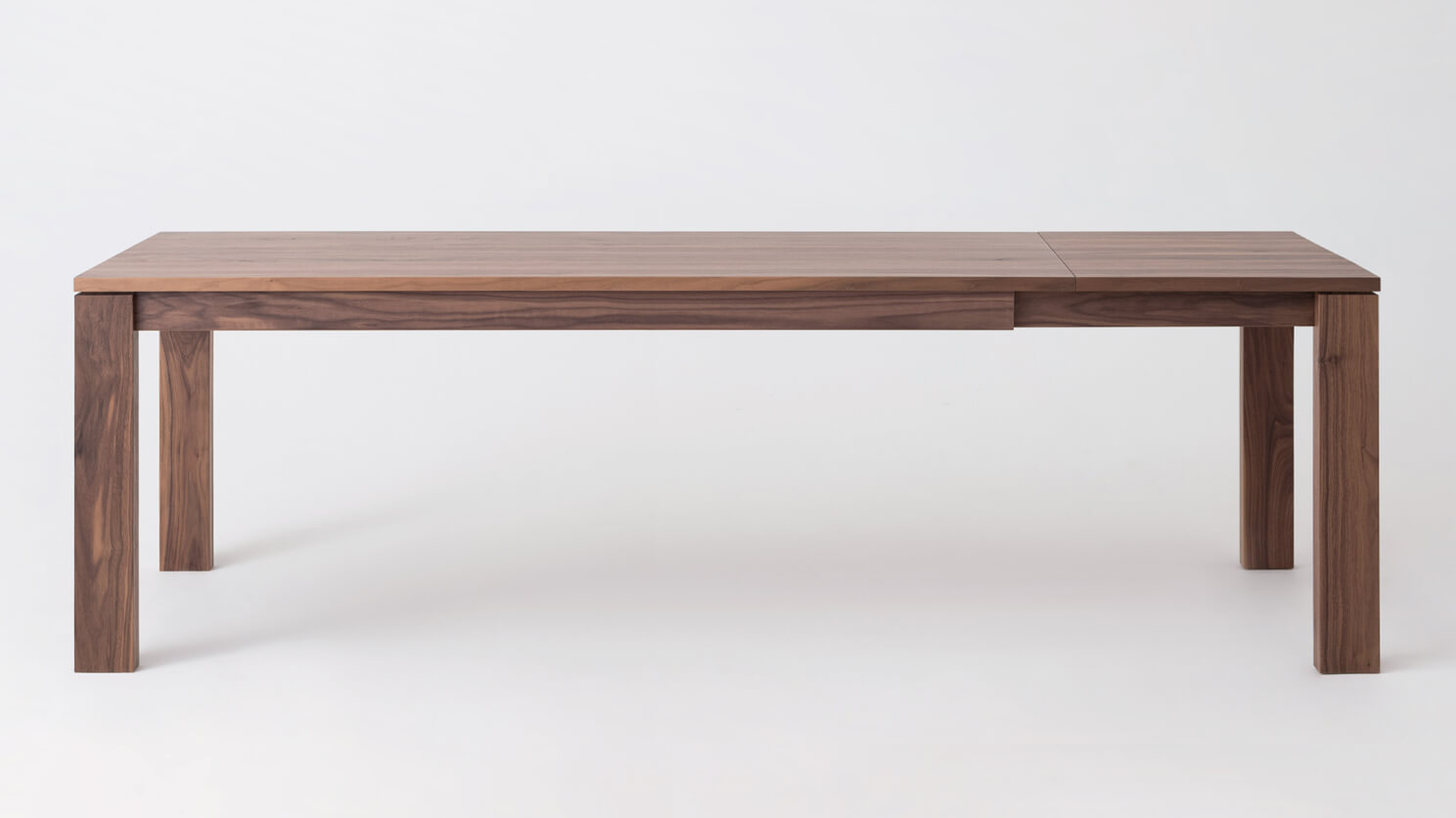 Front view of the large Bon expanded solid wood dining table in walnut