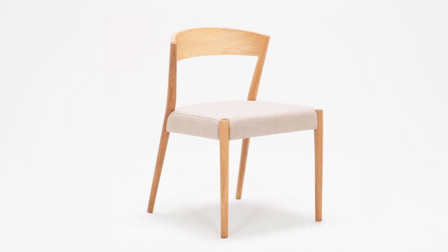 Angled view of the Wren upholstered dining chair in oak with wood back