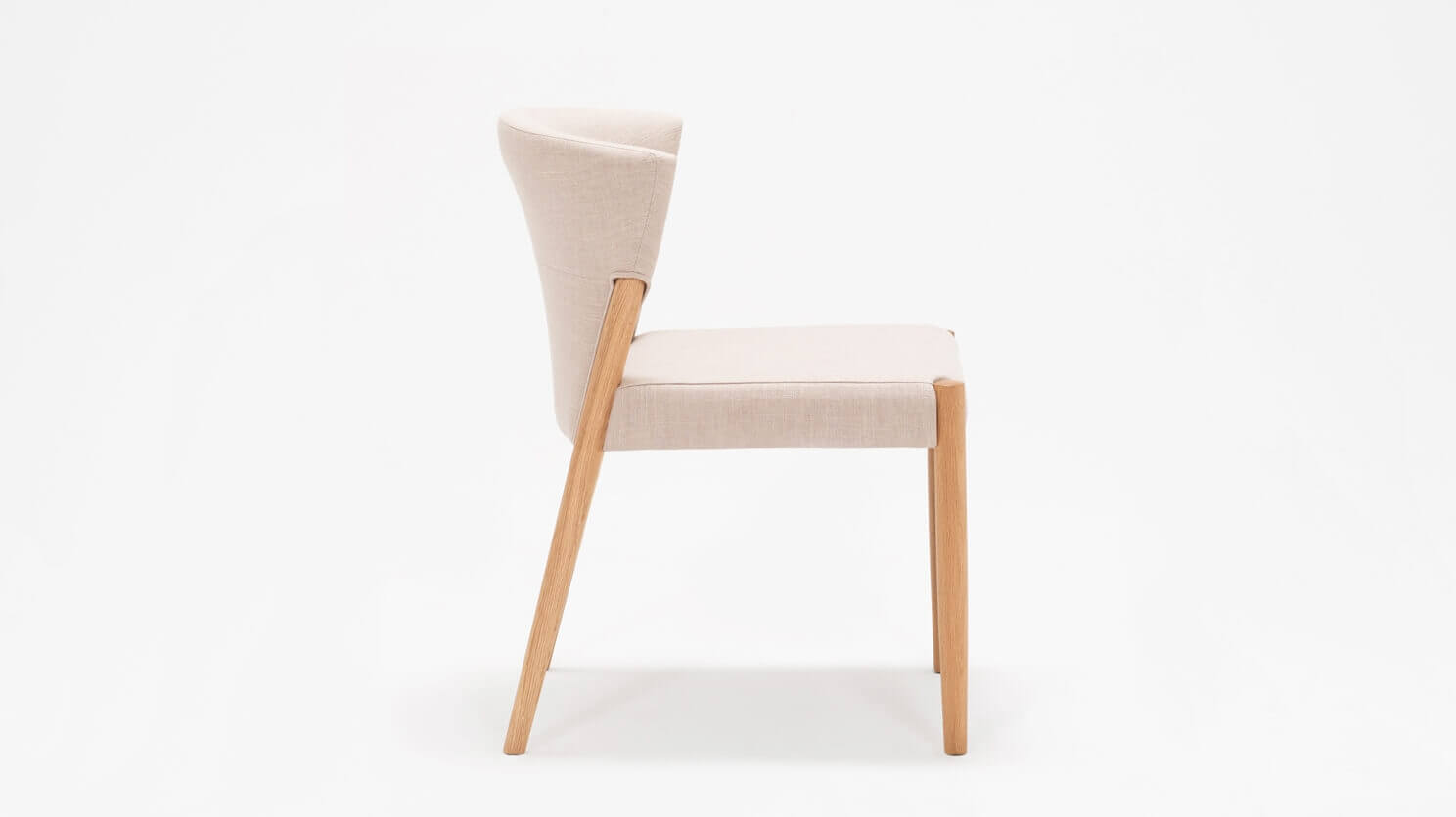 Side view of the Wren fabric dining chair in oak with upholstered back