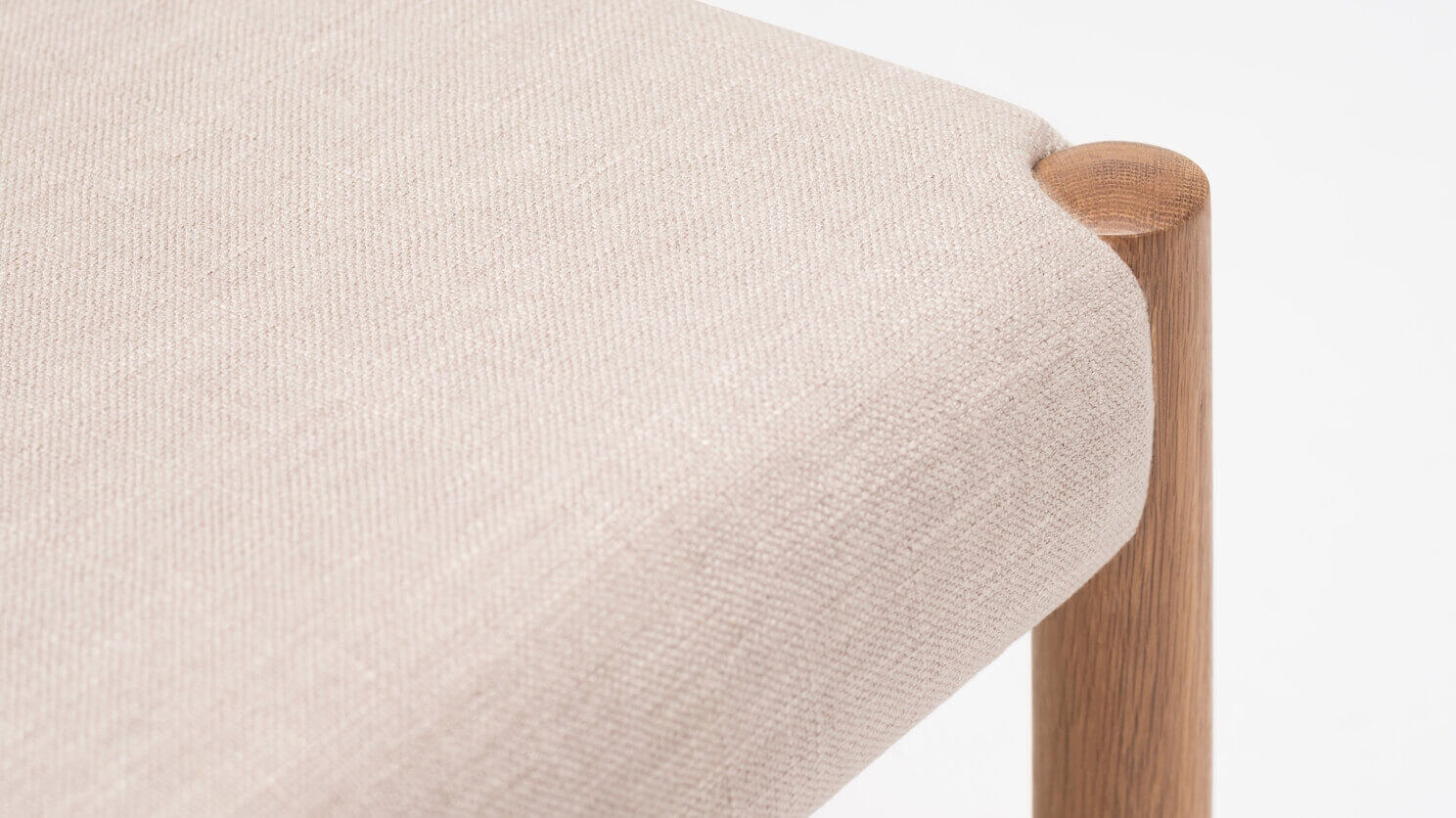 Detail view of the Wren fabric dining chair in oak with upholstered back