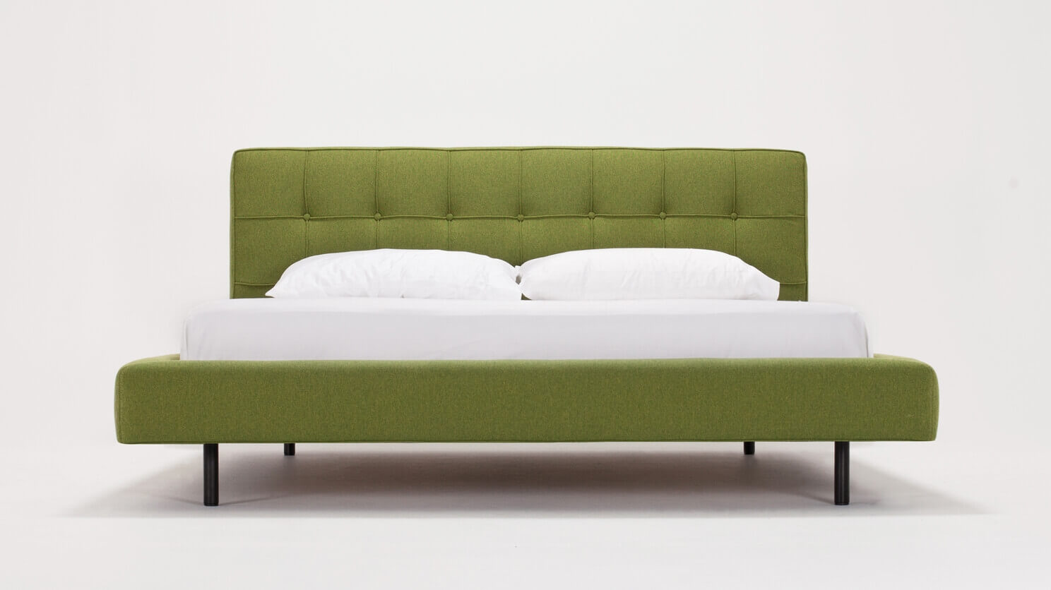 Front view of the mid century modern bed Winston in green fabric