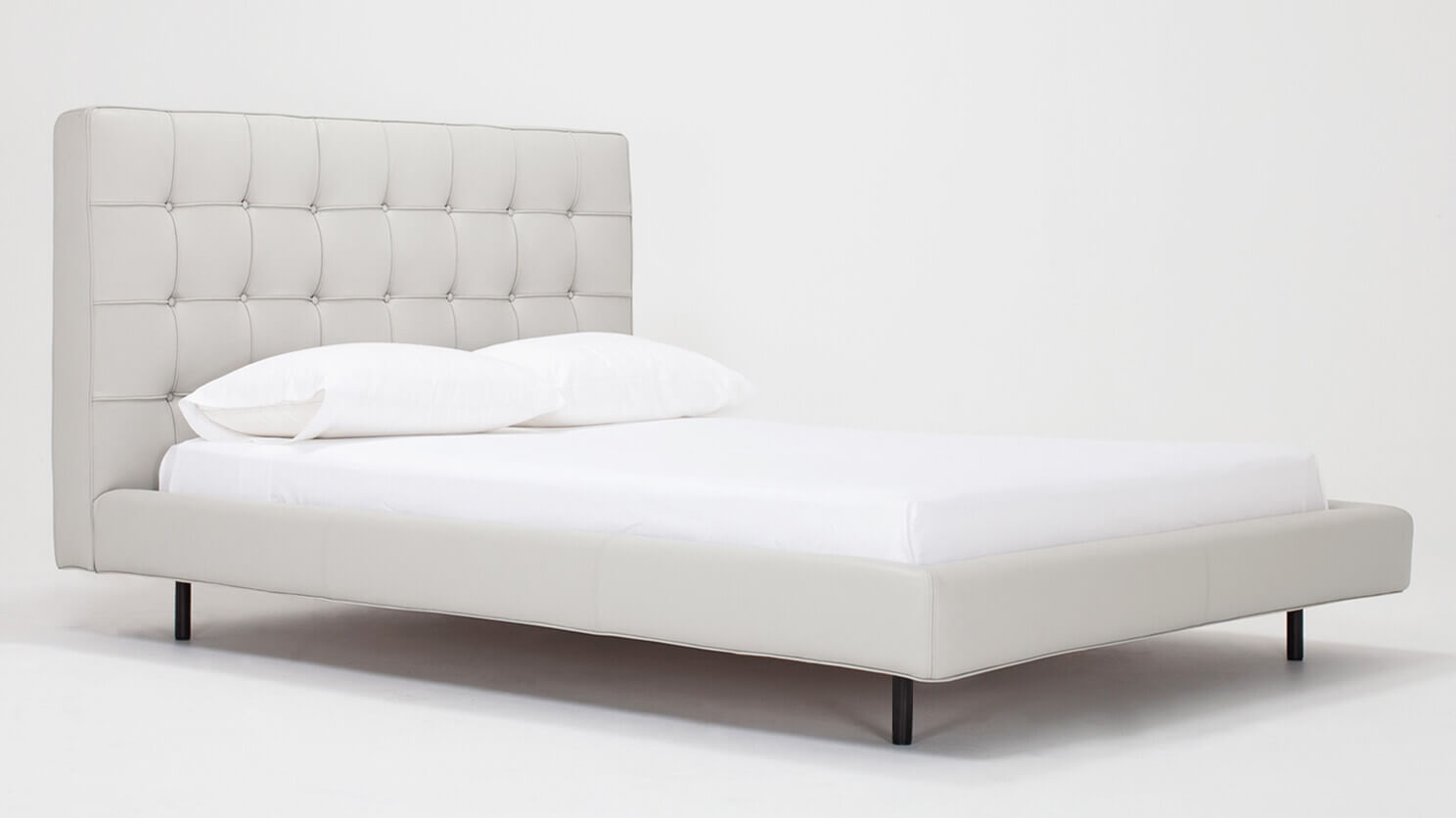 Corner view of Winston, the mid century modern bed, in pale grey leather with a high headboard