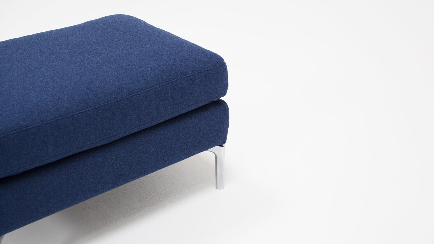 Detail view of the Eve mid century ottoman in blue fabric