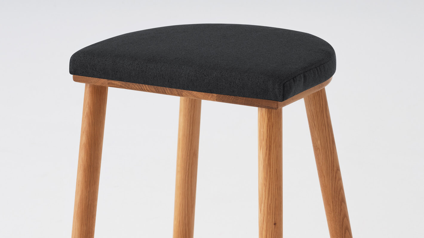 Detail view of the Lima custom counter stool with black seat and oak base