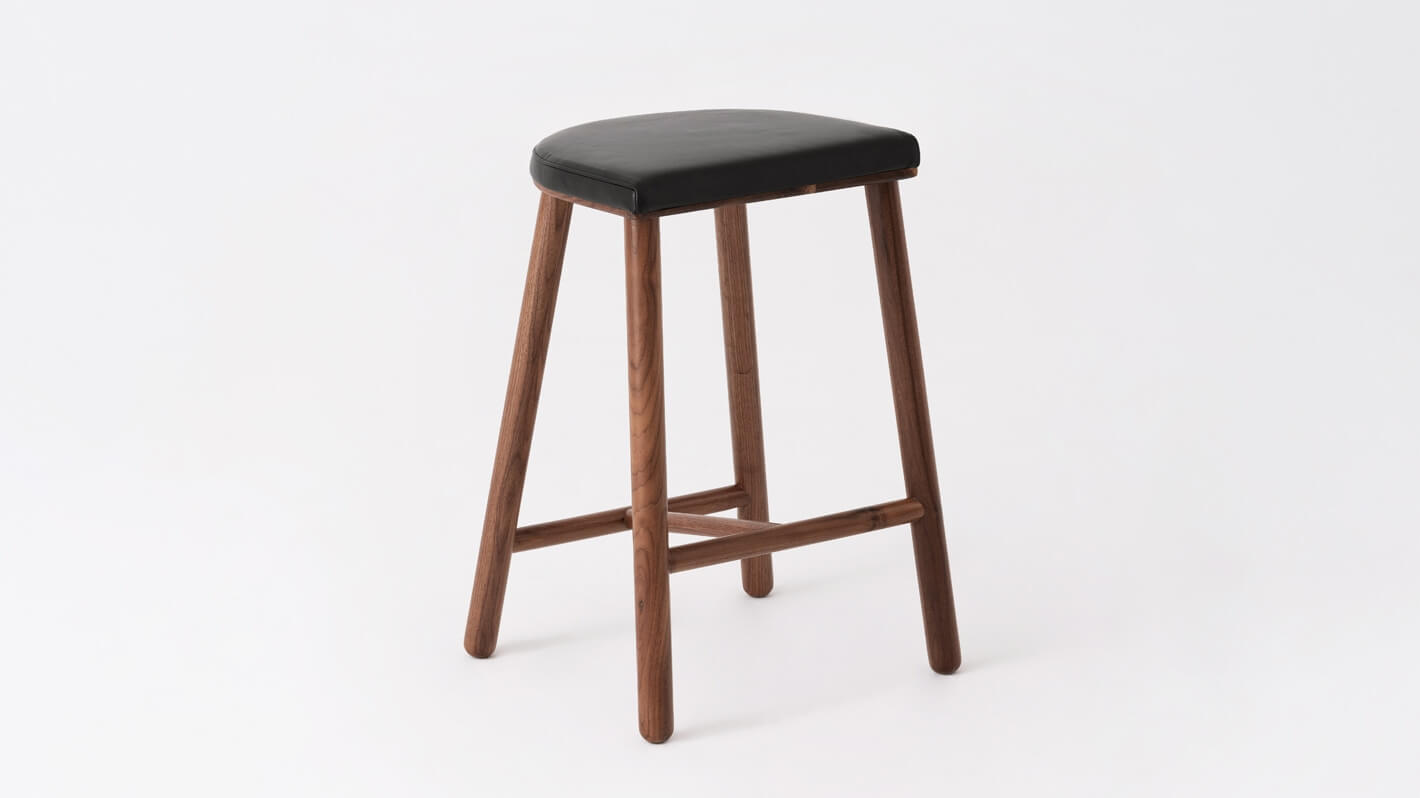 Angled view of the Lima custom counter stool with black leather seat and walnut base