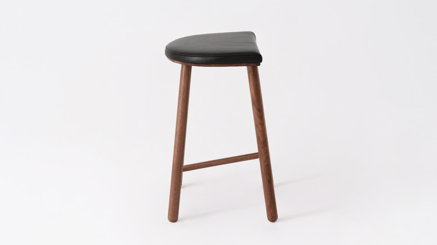 Side view of the Lima custom counter stool with black leather seat and walnut base