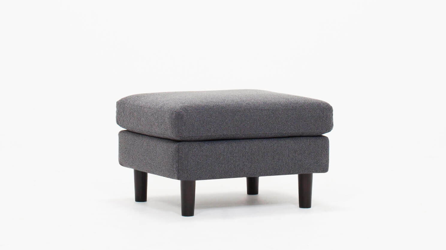 Angled view of the Oskar modern ottoman in grey fabric