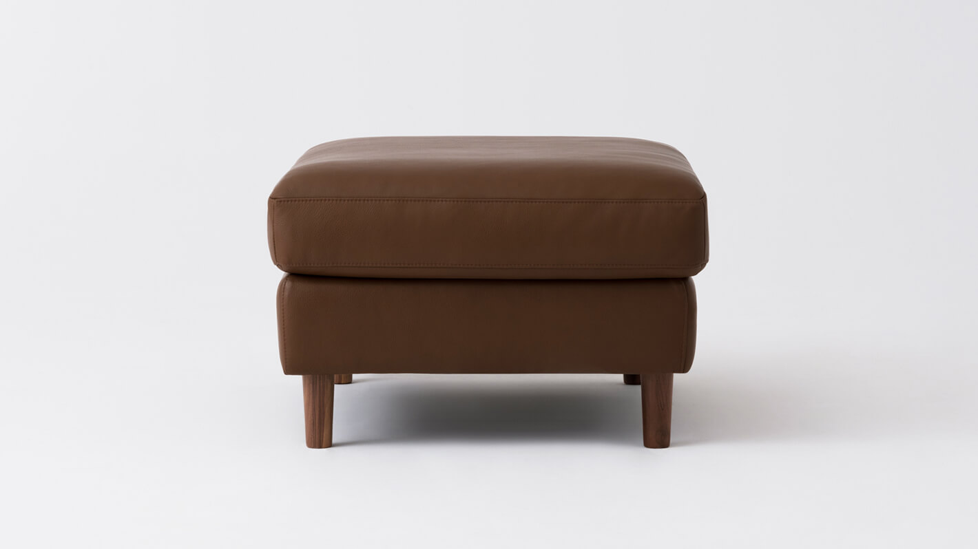 Side view of the Oskar modern ottoman in brown leather