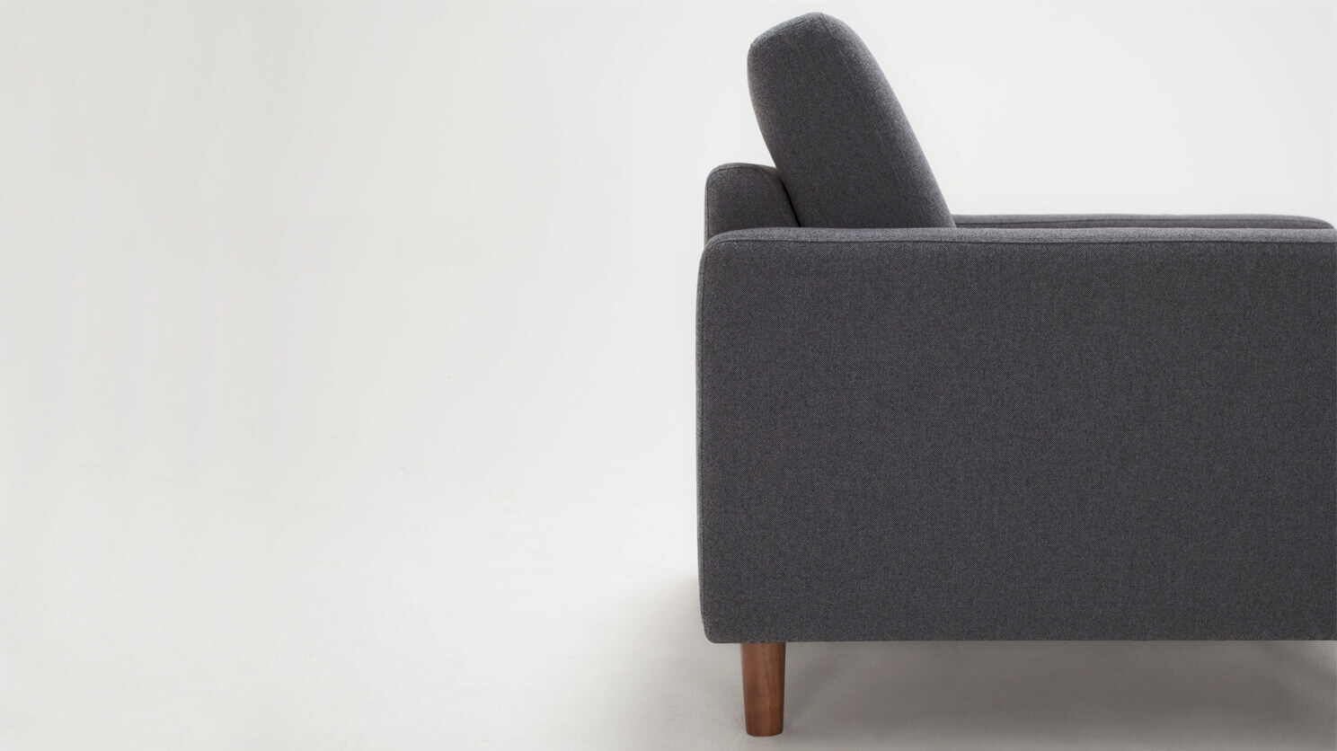 Side detail view of the Oskar modern lounge chair in grey fabric