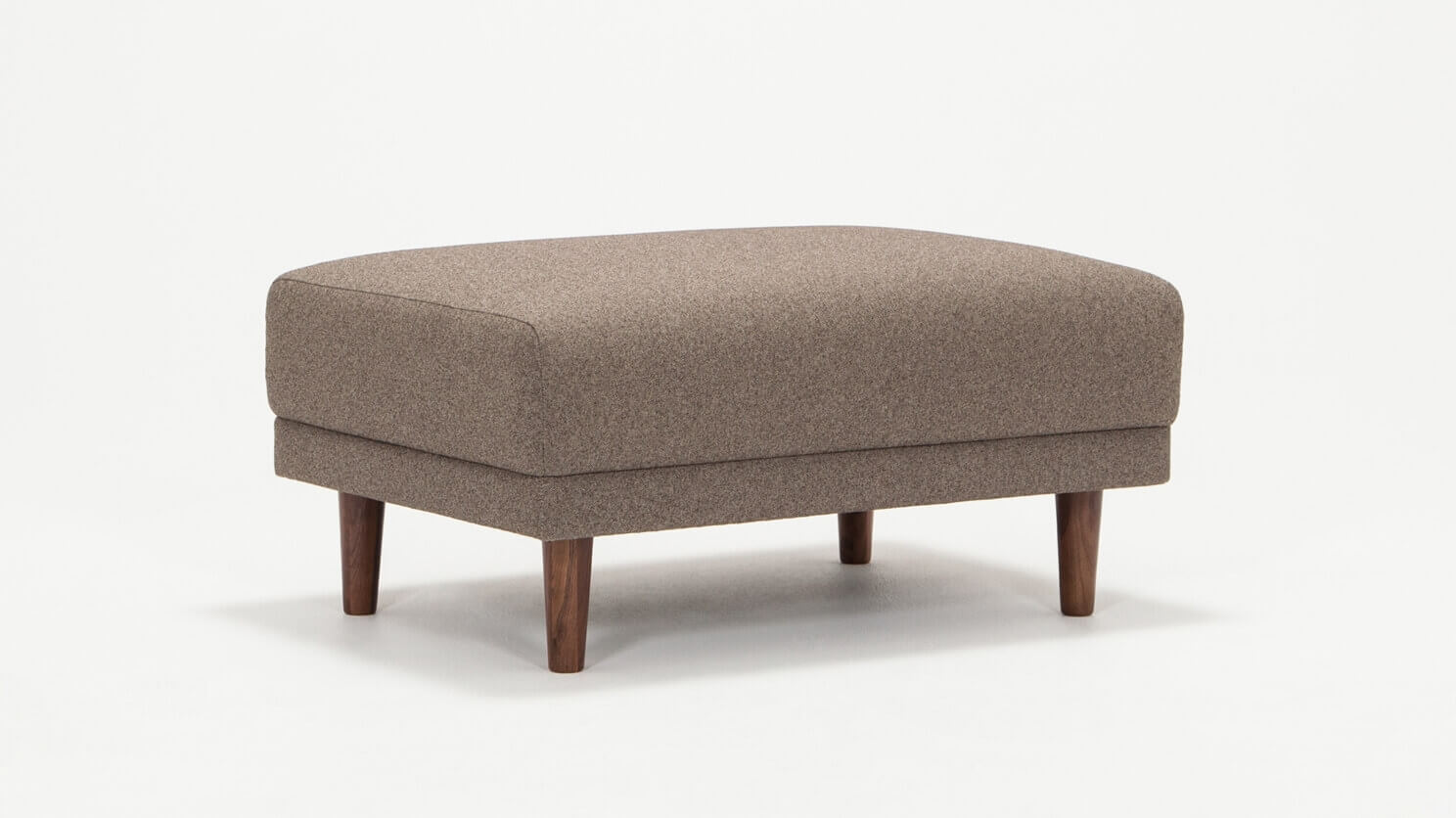 Angled view of the Remi modern ottoman in beige fabric