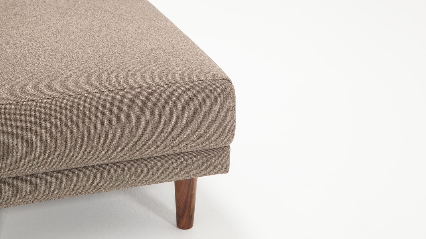 Detail view of the Remi modern ottoman in beige fabric