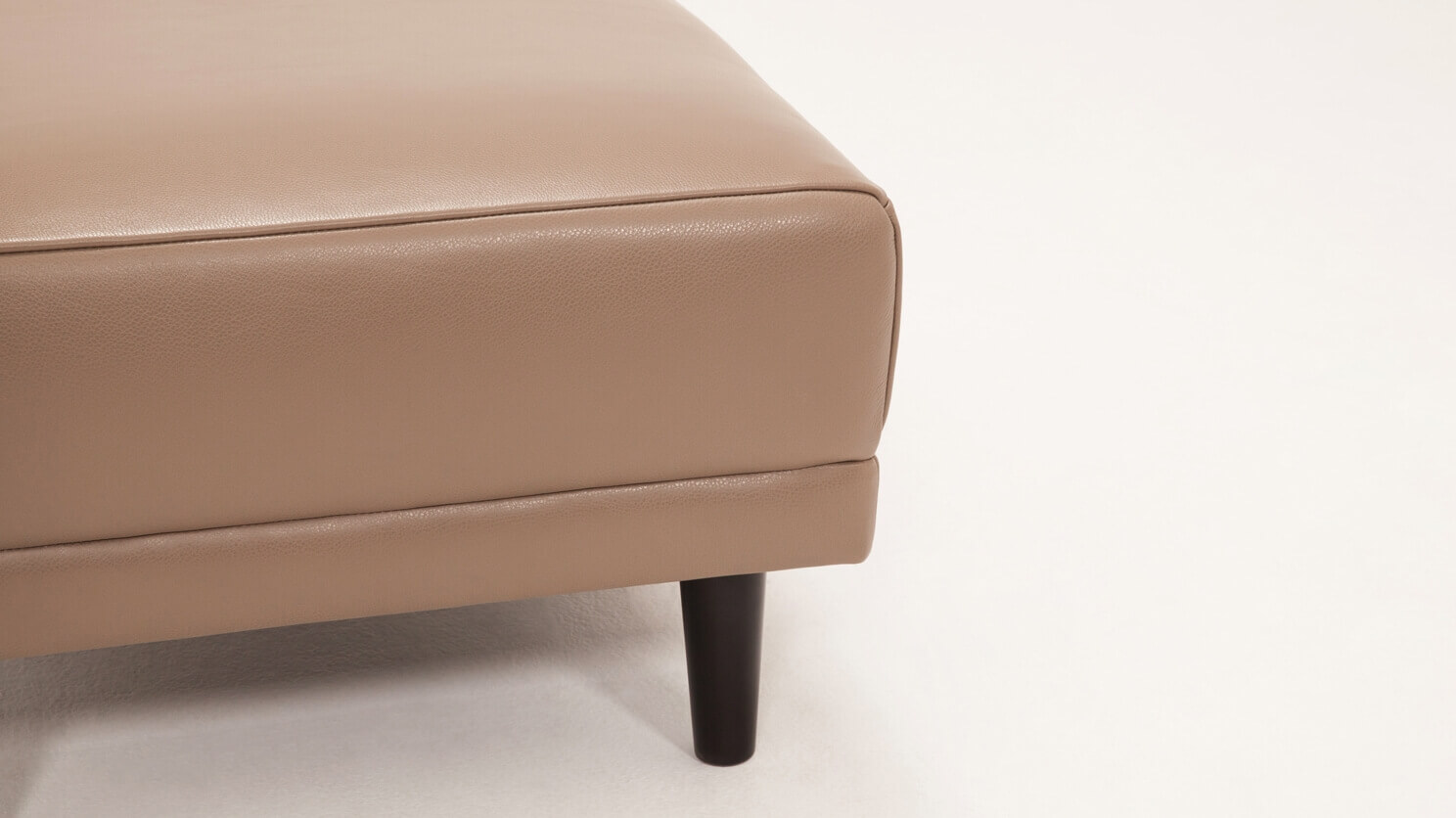 Detail view of the Remi modern ottoman in beige leather