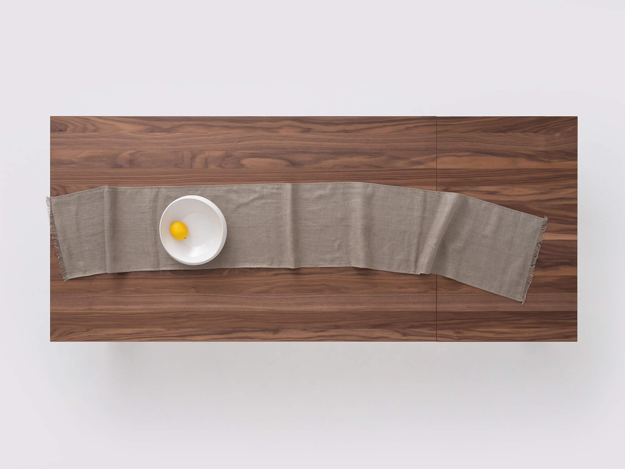 Overhead view of the Faye seafoam table runner on a table with a bowl on it