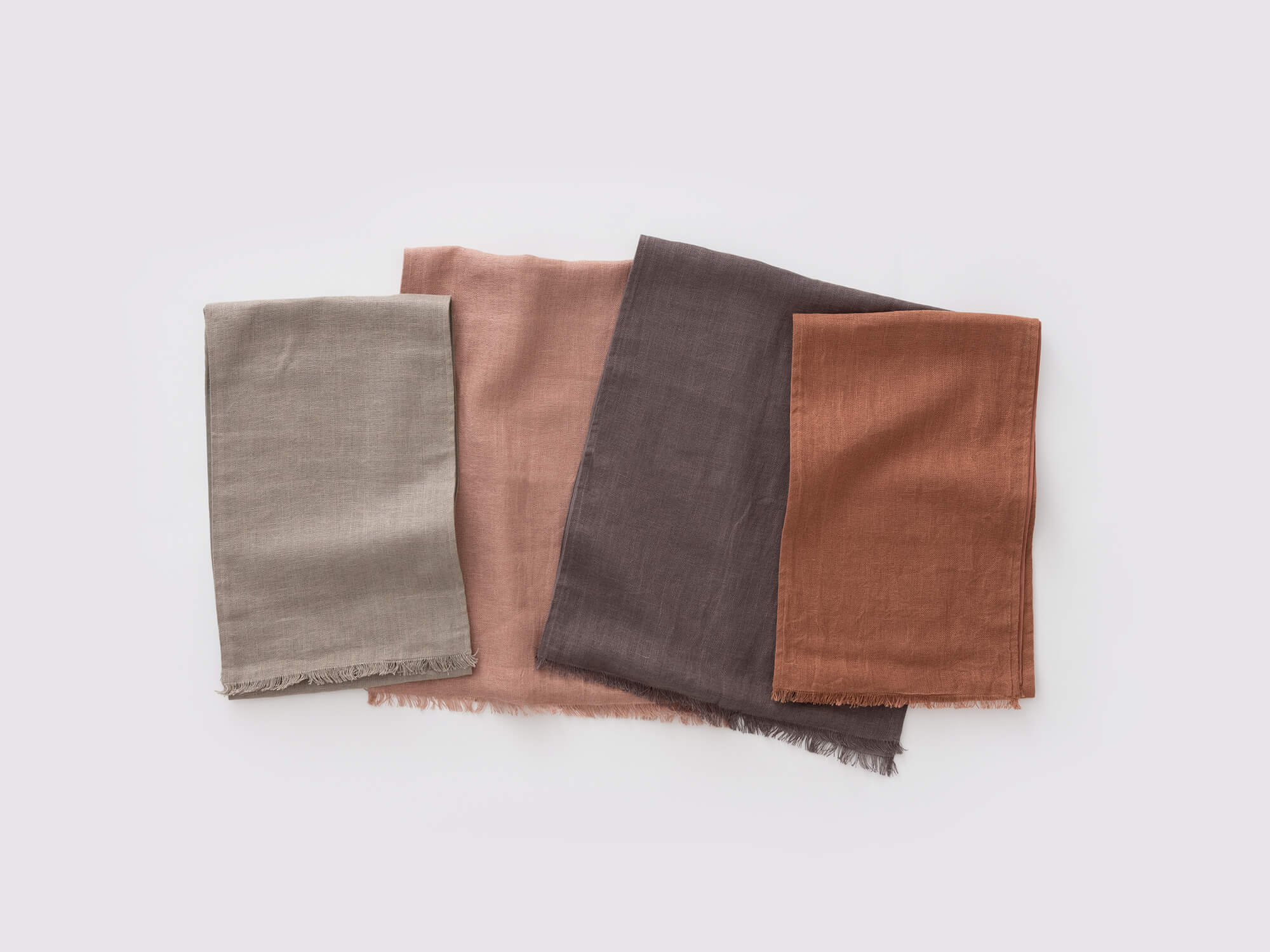 Overhead view of the Faye rustic table runner in burnt red, seafoam, rose, and grey