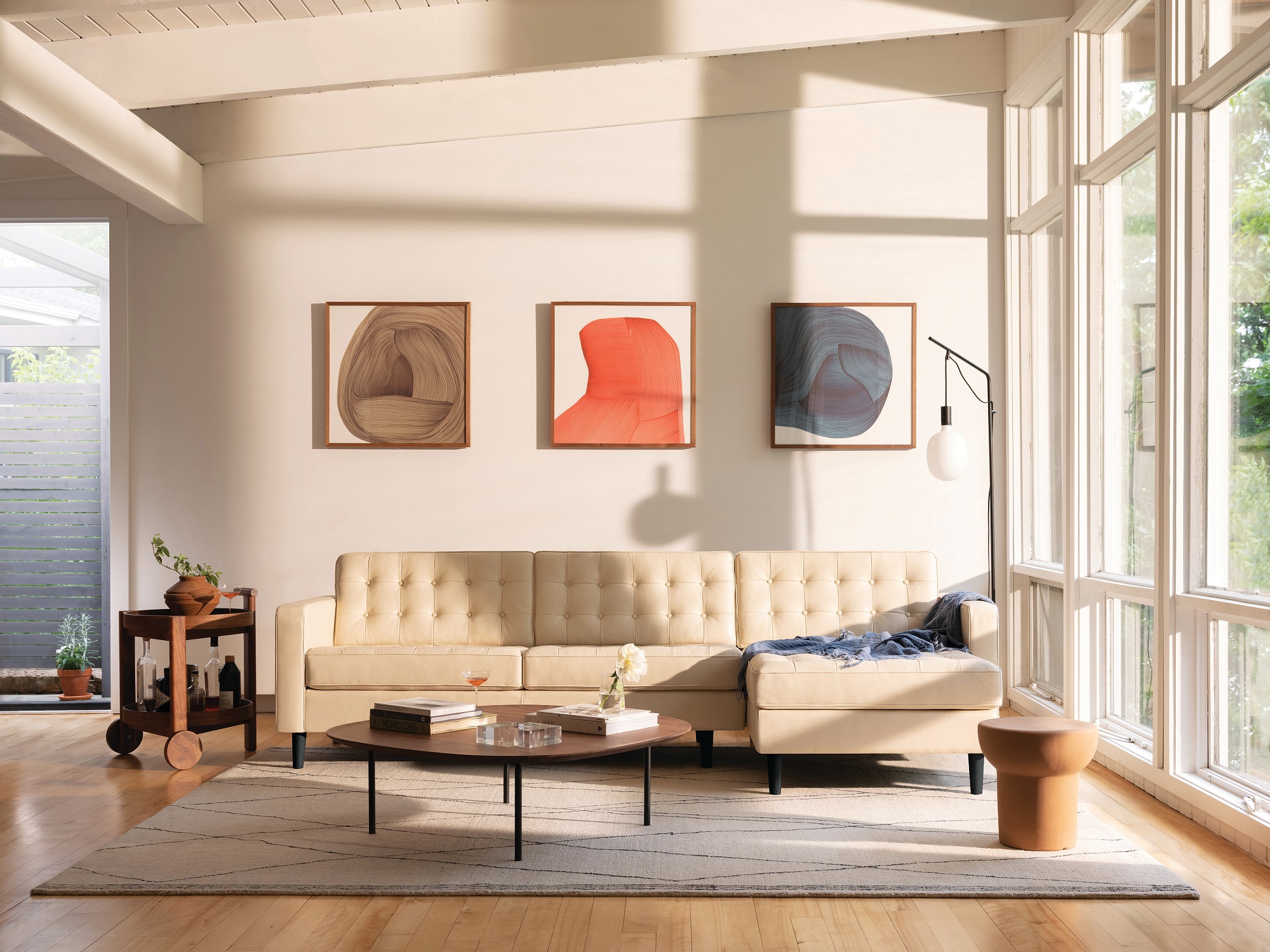 Walnut top square coffee table with beige sectional in bright modern living room