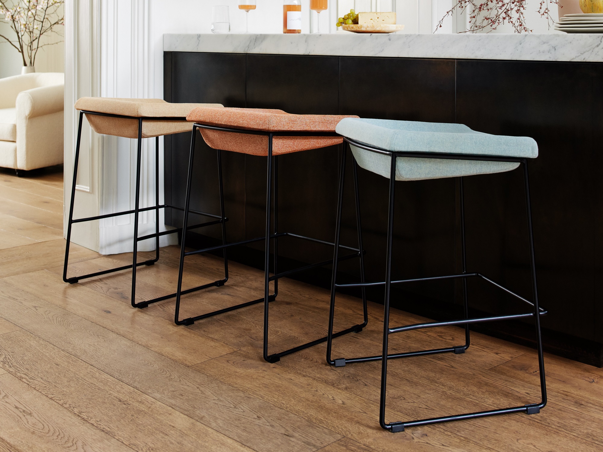 Pastel coloured upholstered counter height stools at colorful kitchen island