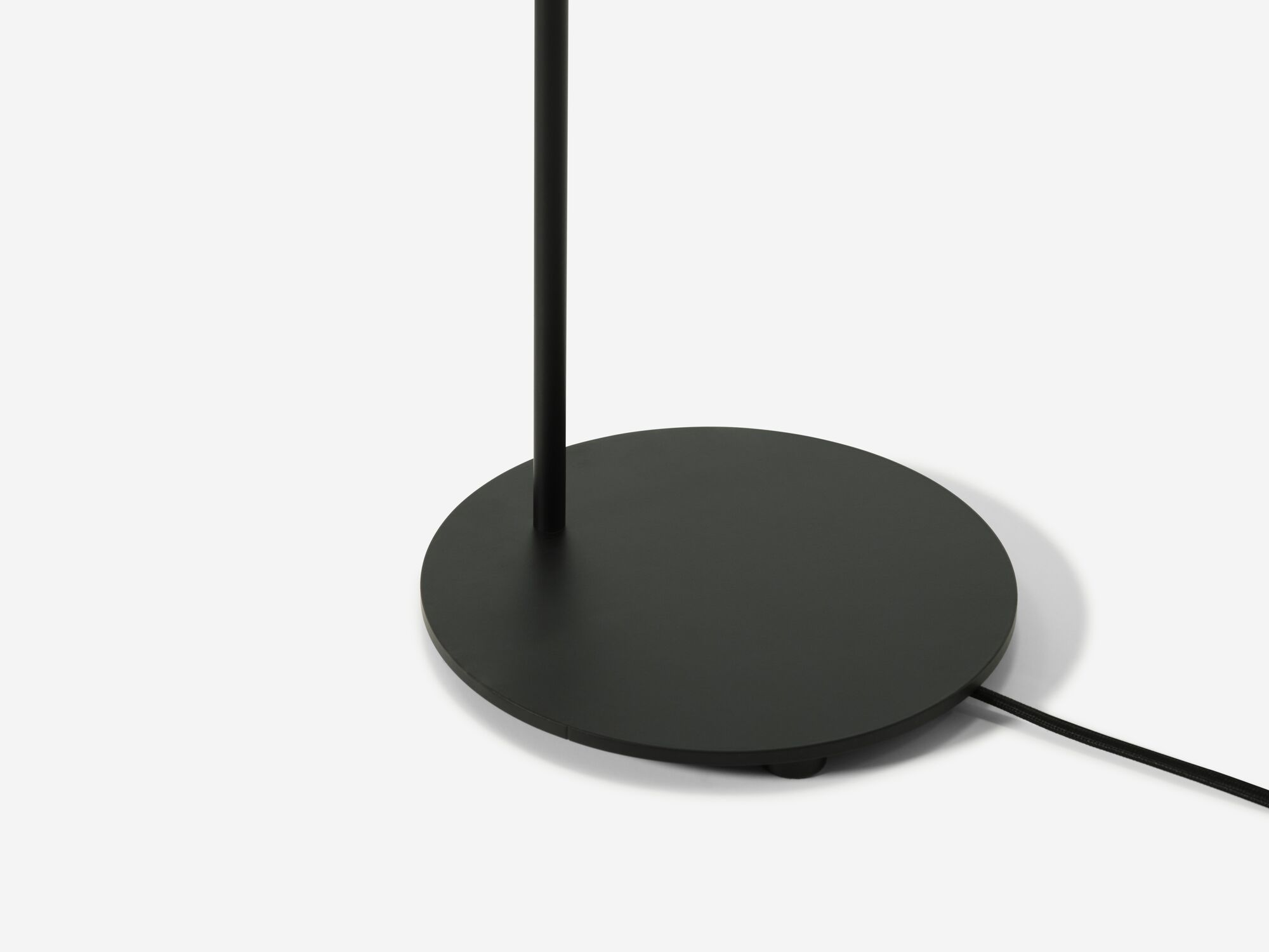 Detail base view of black arched floor lamp