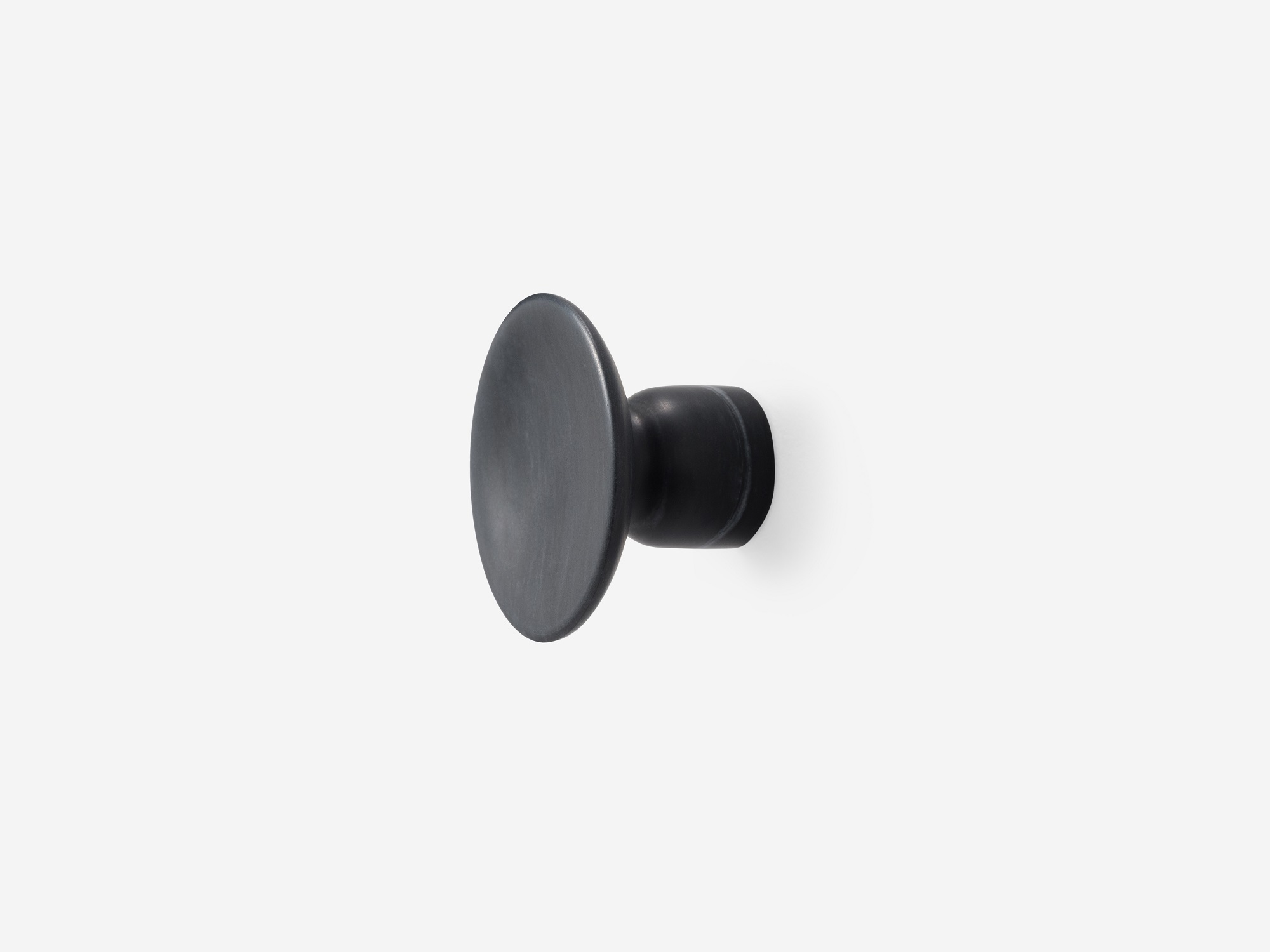 Angled view of large black marble coat hook