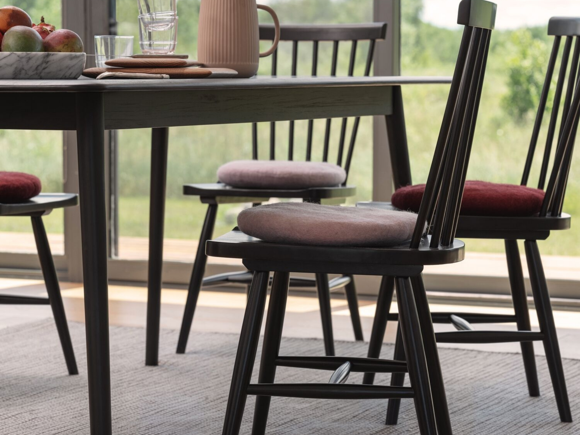 Black side chairs with seat cushions at a matching dining table