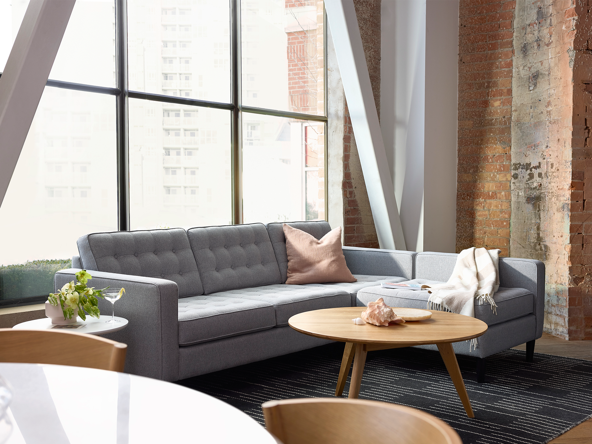 Light grey sectional sofa with oak coffee table in modern living space