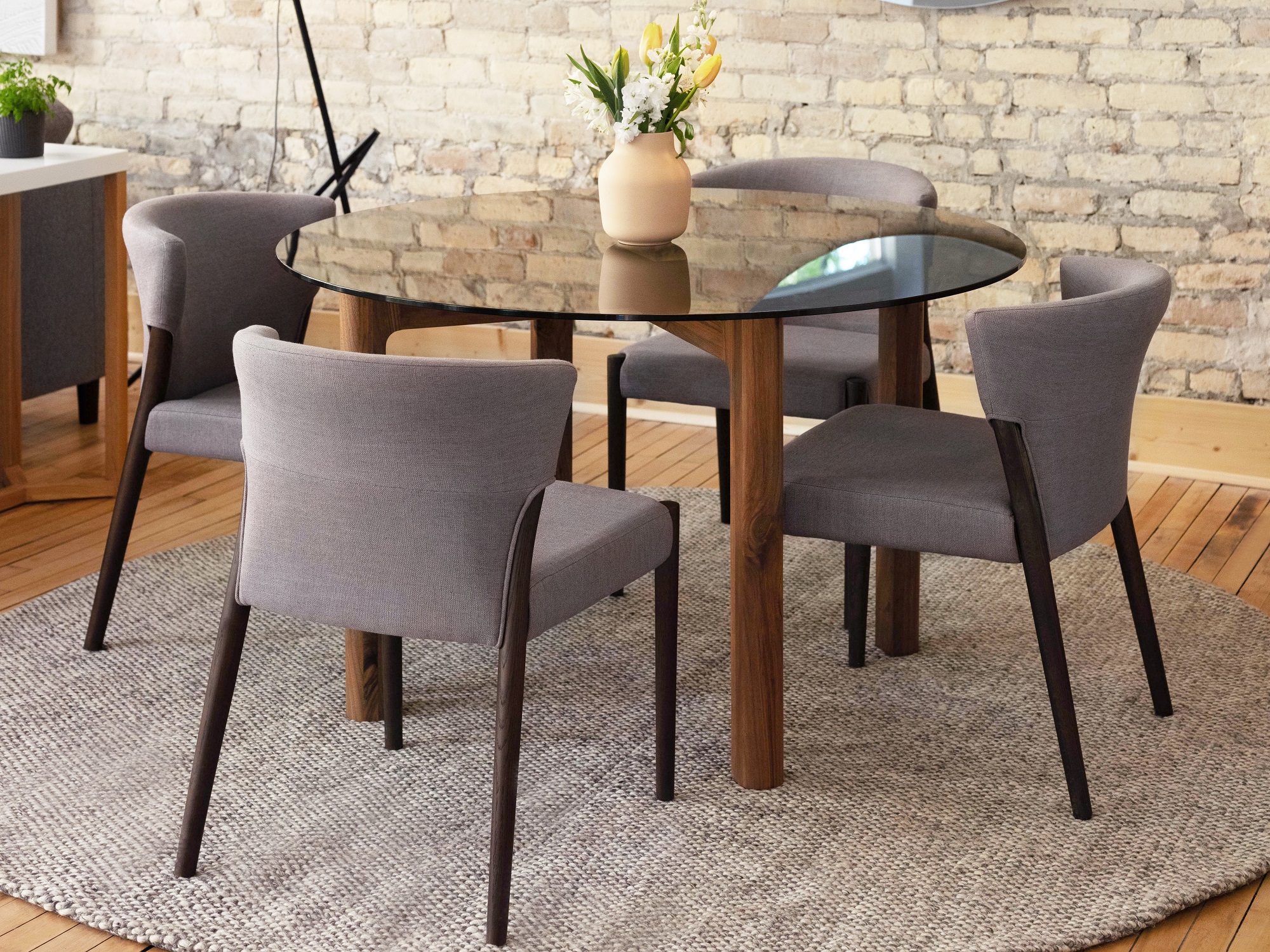 Grey and black oak upholstered chairs around glass dinette in modern dining room