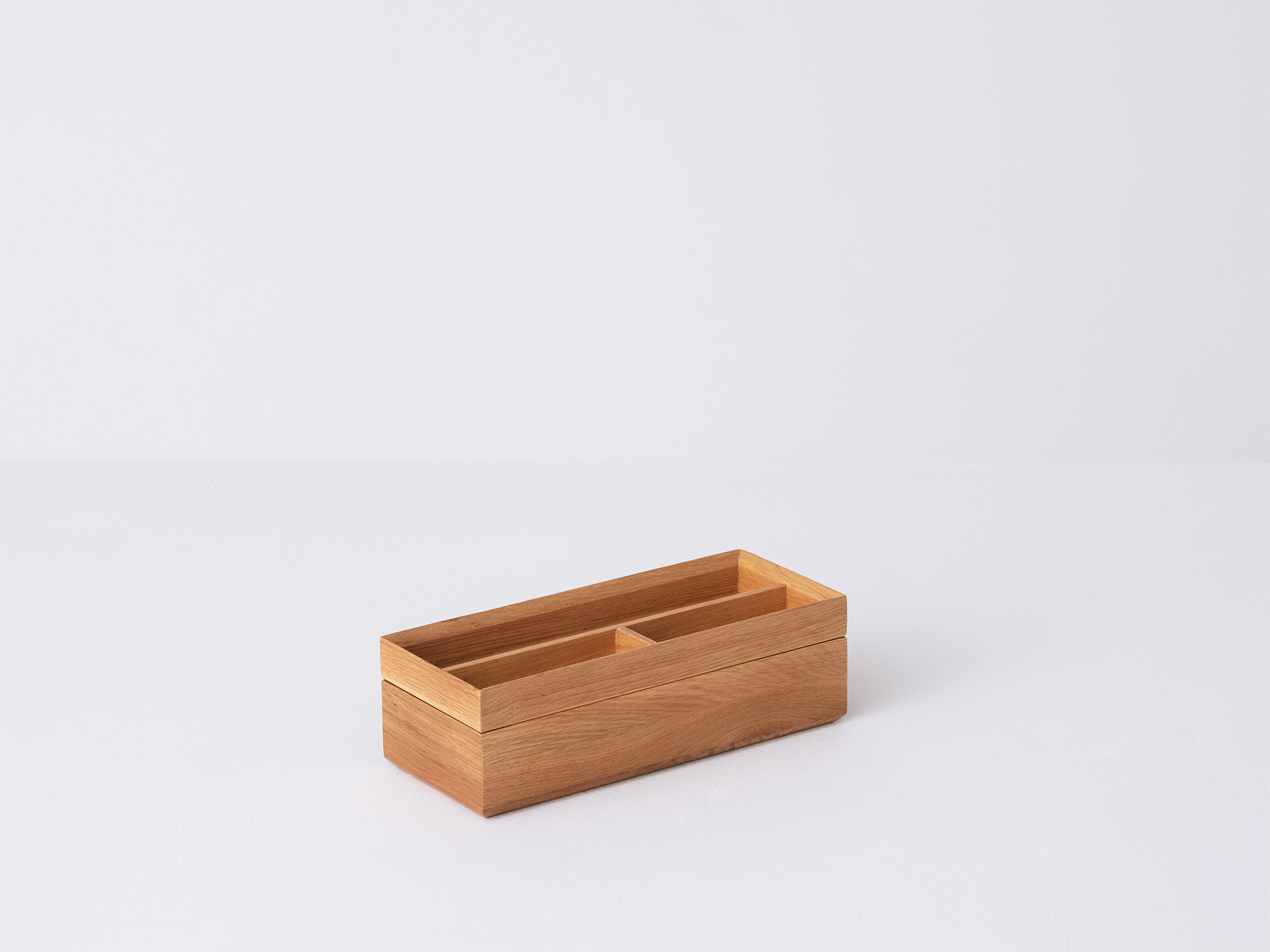 Angled view of the small wooden Draft Pencil Box in oak