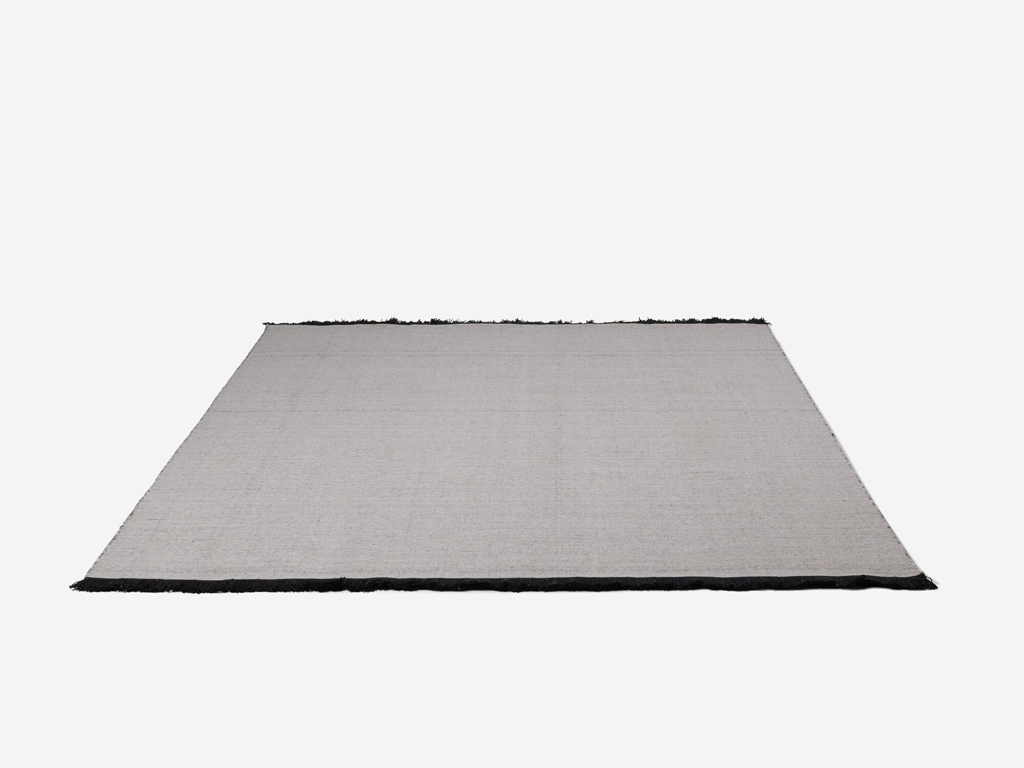 Side view of large grey braided wool rug