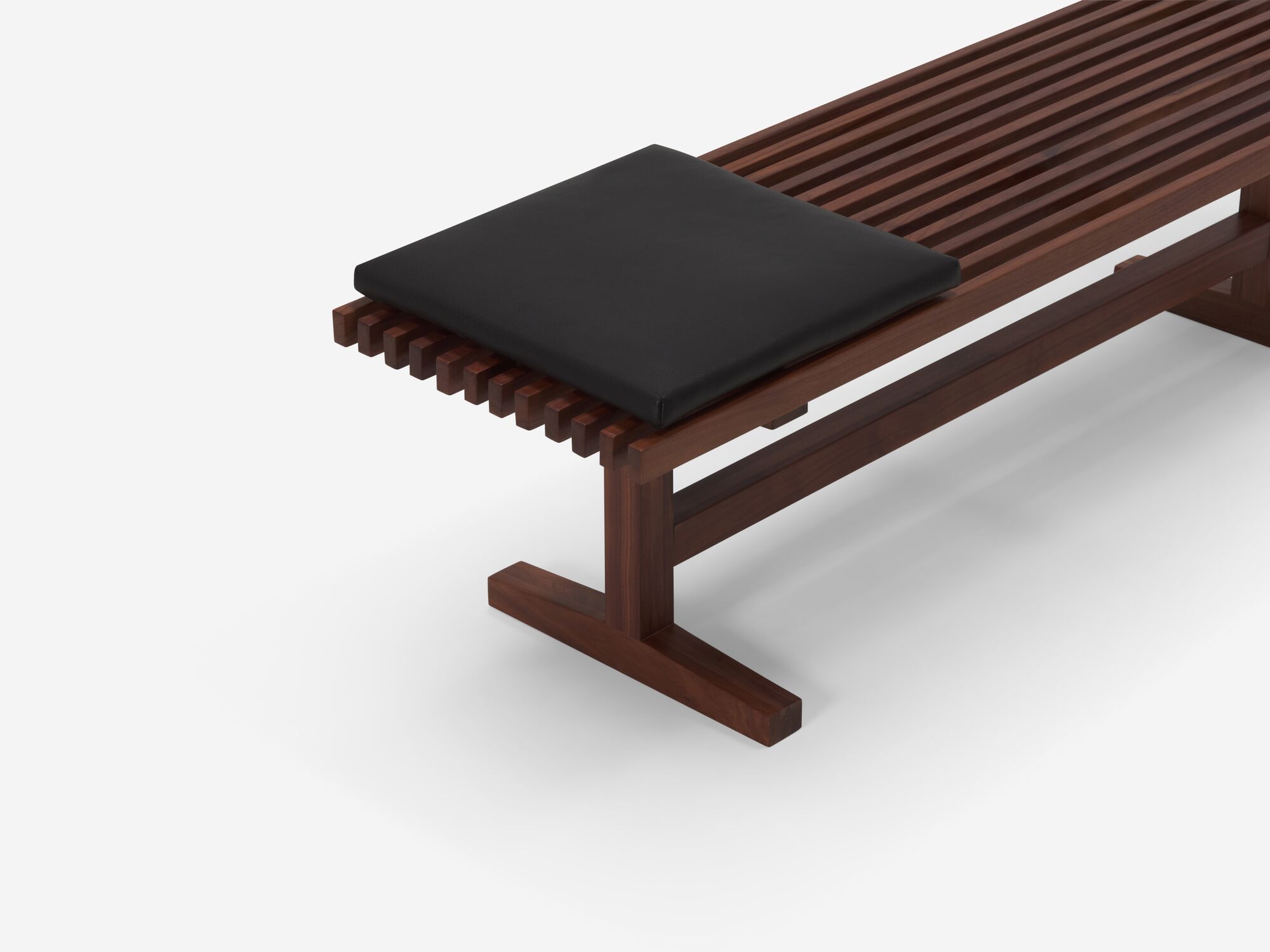 Top angle view of square black leather cushion on walnut bench