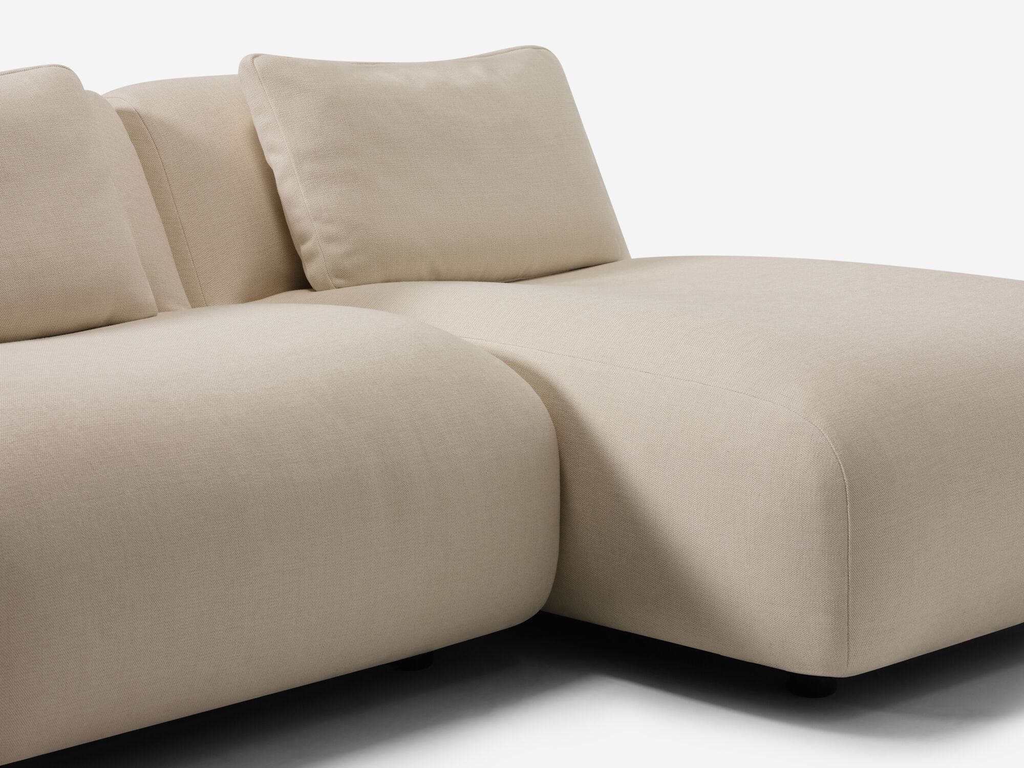 Chaise detail view of beige armless sectional