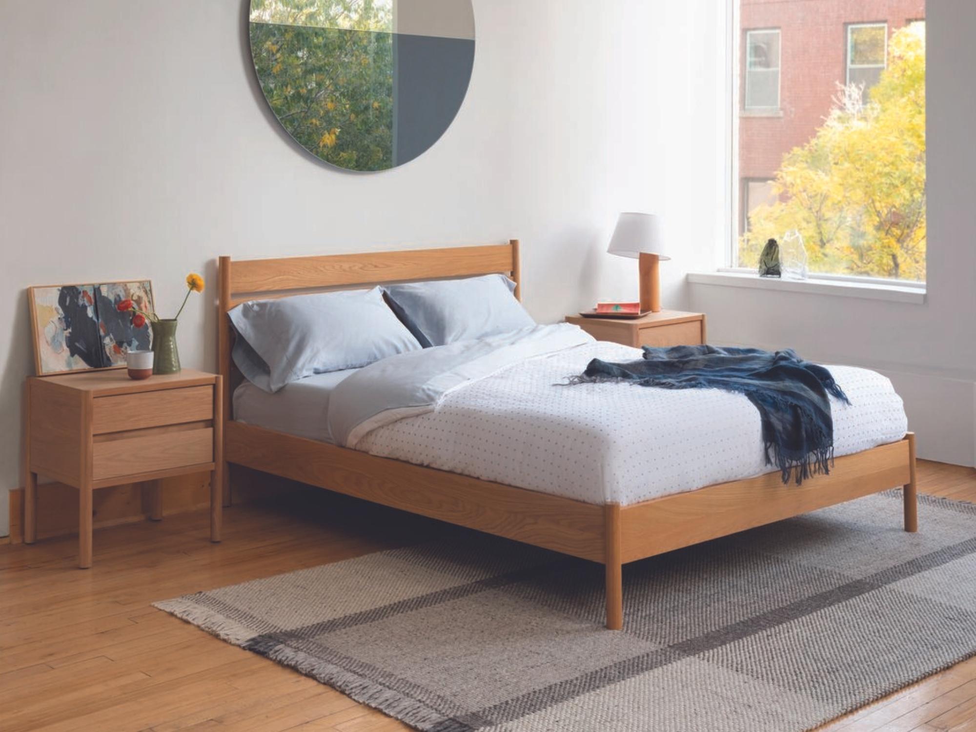 Blue throw blanket on oak bed frame in modern bedroom