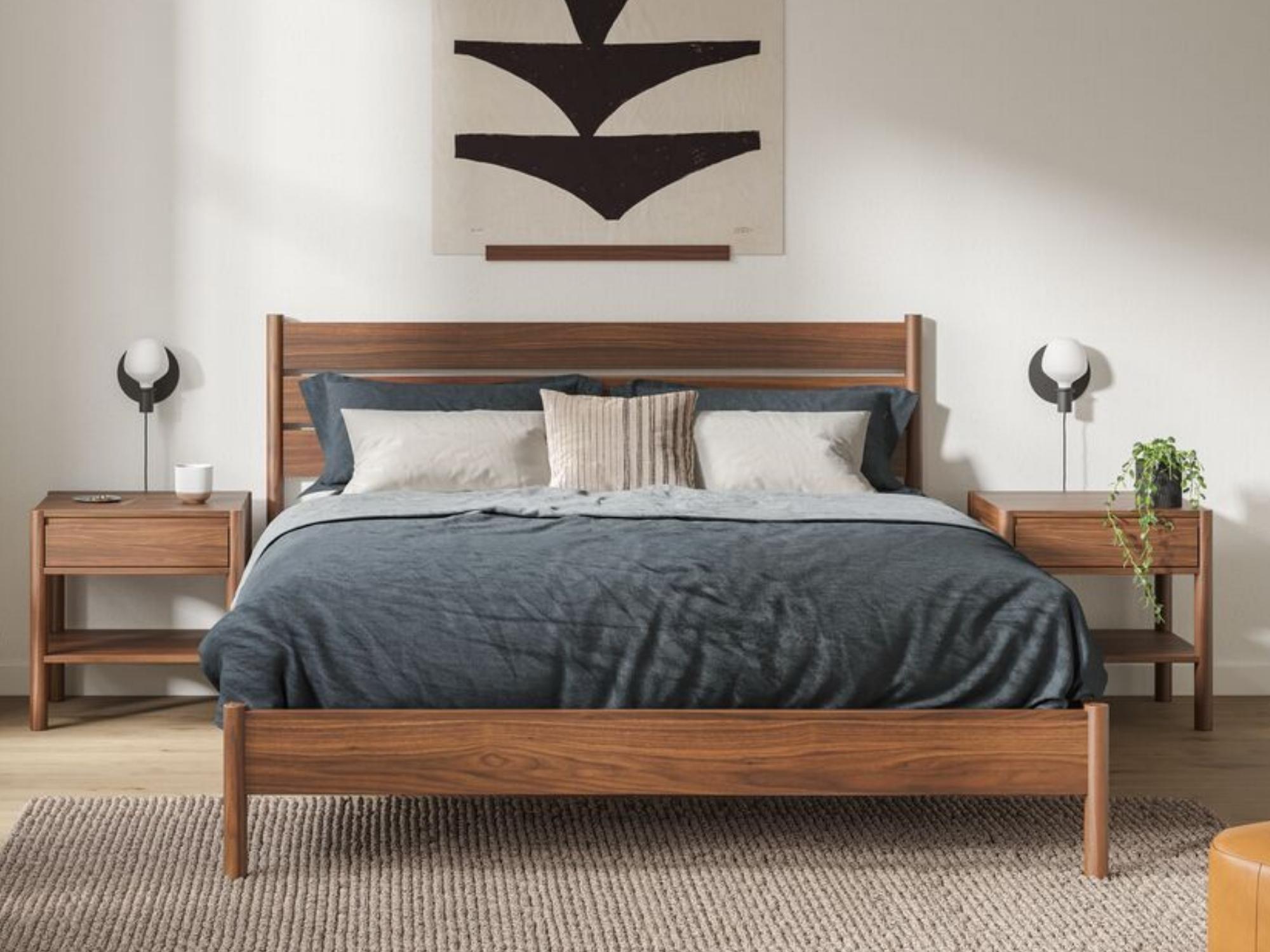 Black and beige accent pillow on walnut bed in midcentury bedroom