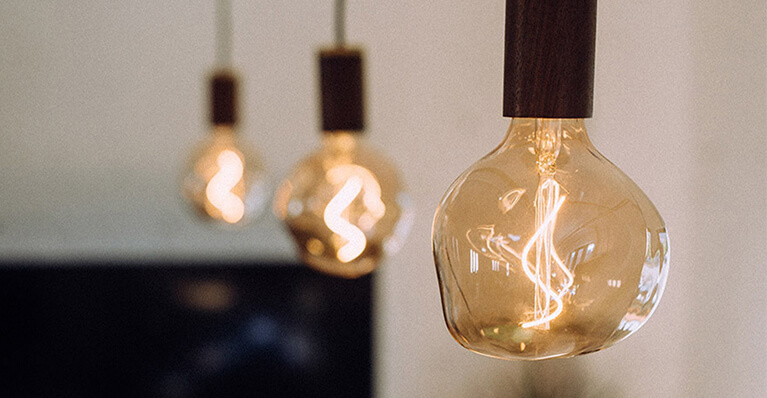 Trois petites ampoules de style Edison sont exposées en détail suspendues et allumées. Lien vers la catégorie de marque Tala