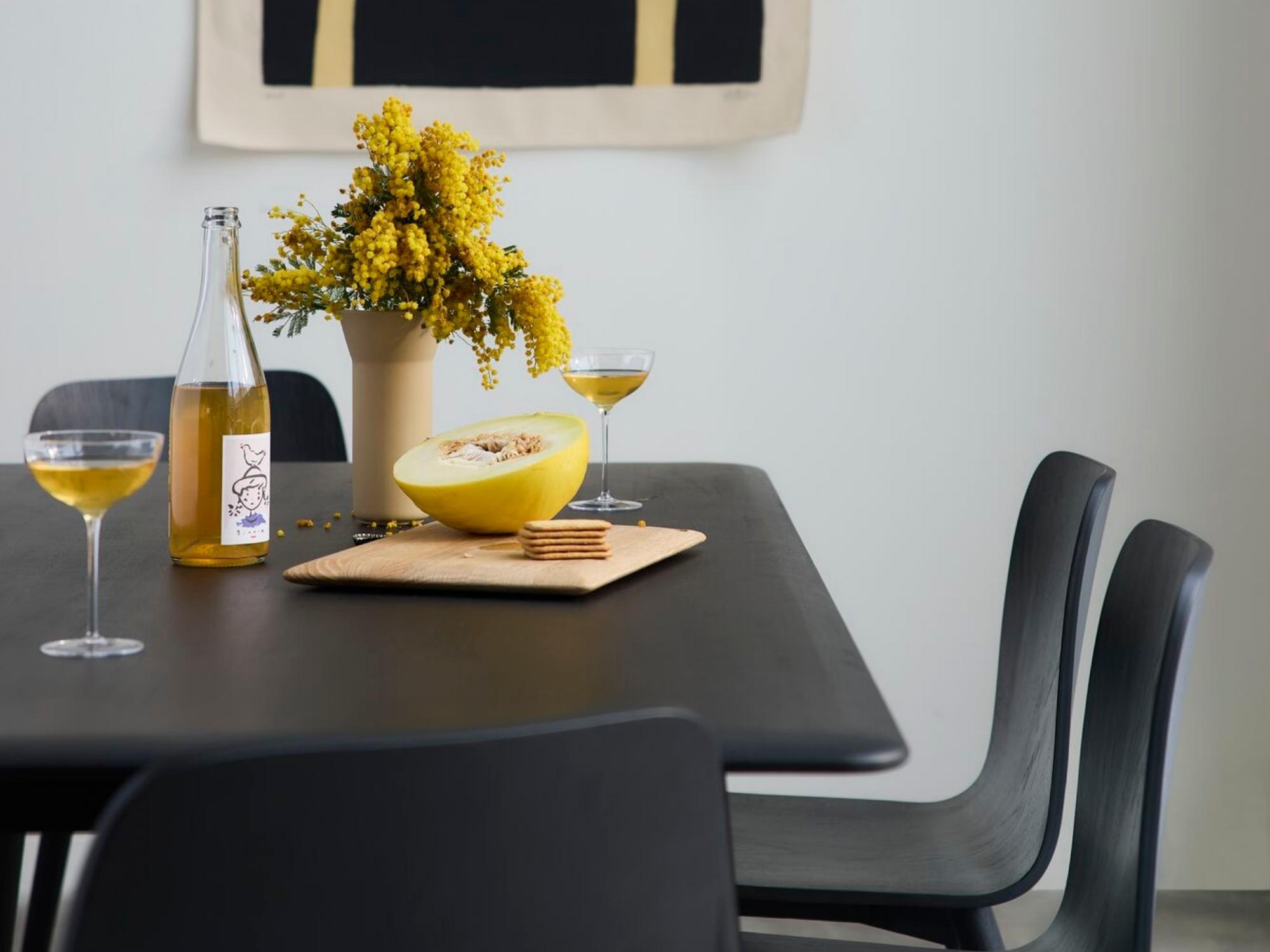 Champagne glass and bottle on black dining room table